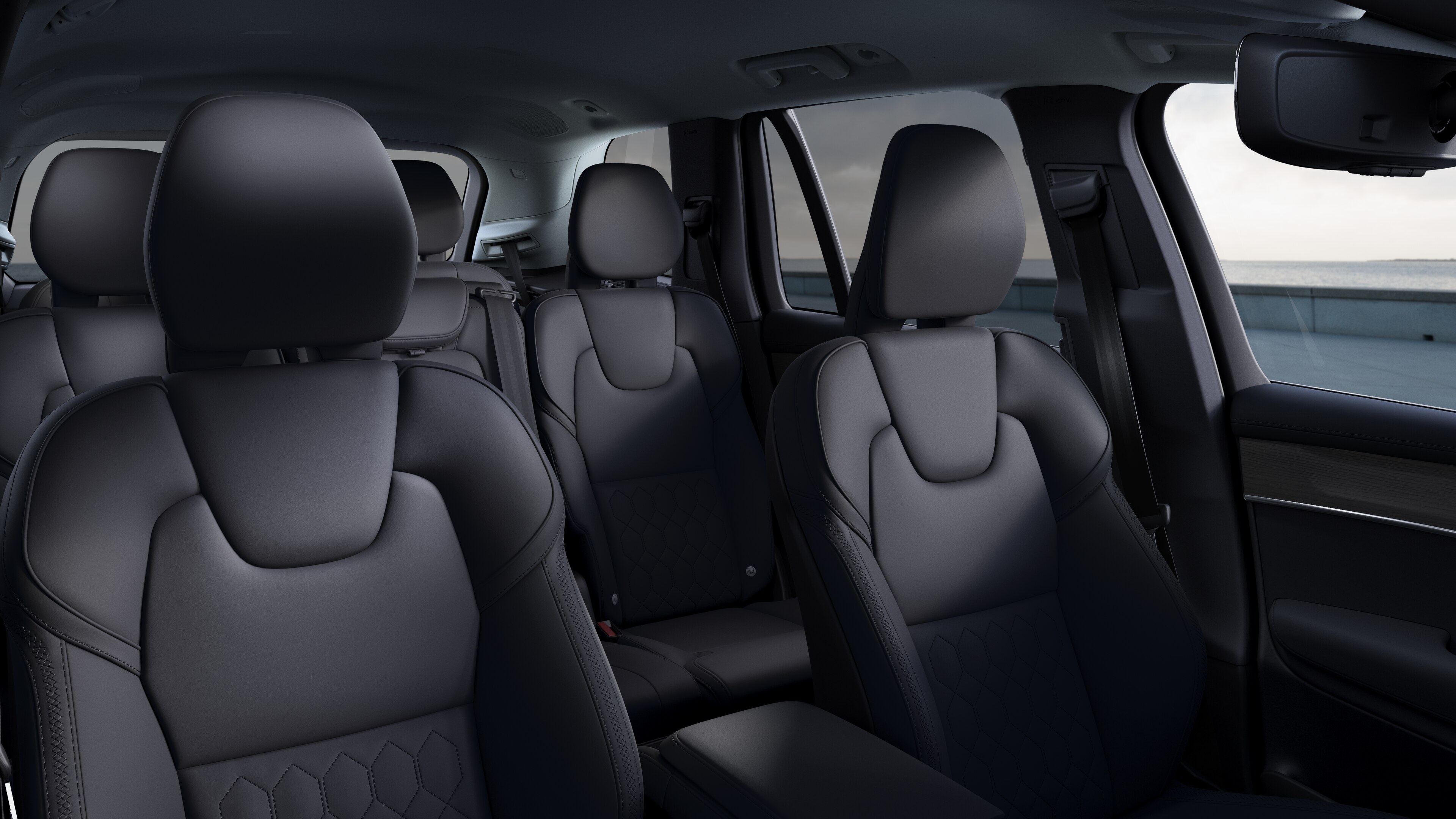 Volvo avtomobil interyeri ön və arxa sərnişin oturacaqları, sükan, dashboard, və sadə studiya fon qarşı mərkəz konsolu göstərir.