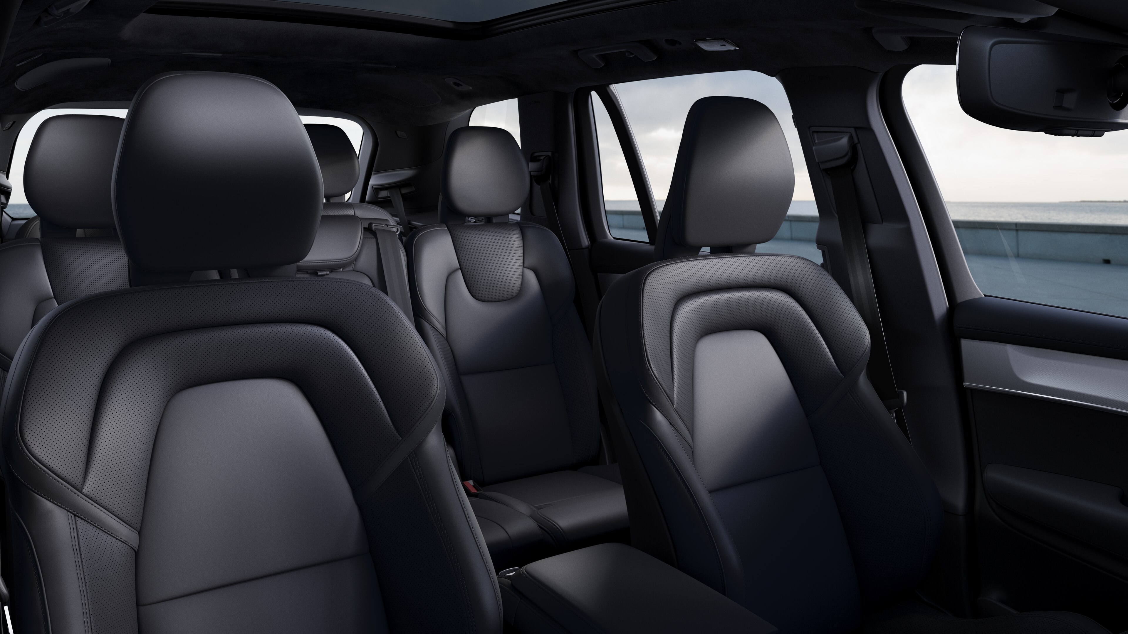 Der Innenraum eines Volvo Fahrzeugs zeigt Beifahrer- und Beifahrersitze, Lenkrad, Armaturenbrett und Mittelkonsole vor einem schlichten Studiohintergrund.