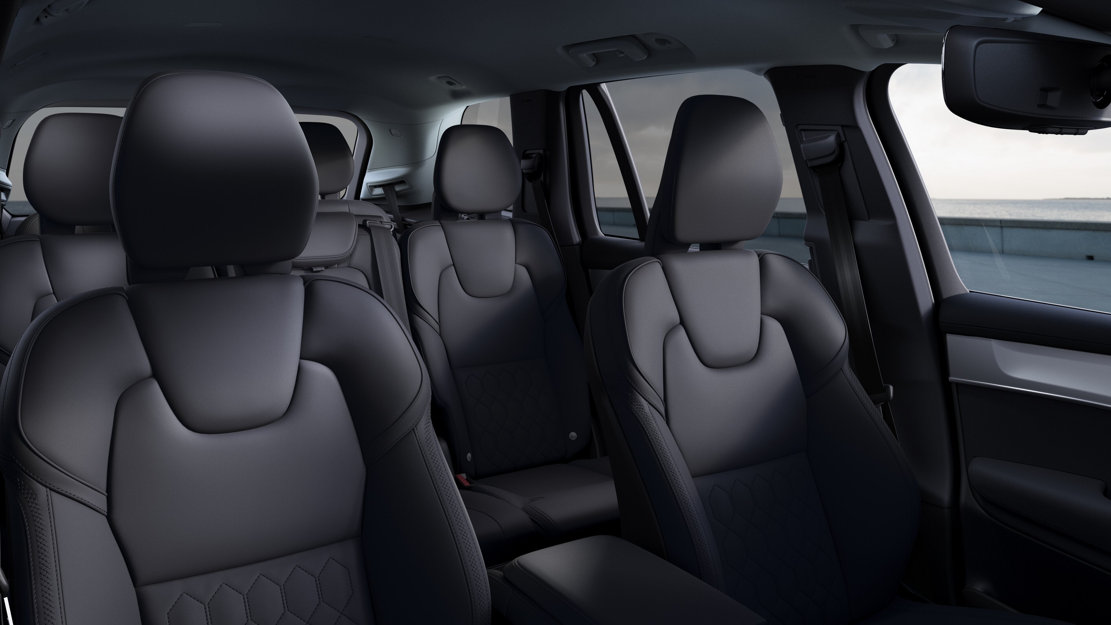 Volvo avtomobil interyeri ön və arxa sərnişin oturacaqları, sükan, dashboard, və sadə studiya fon qarşı mərkəz konsolu göstərir.