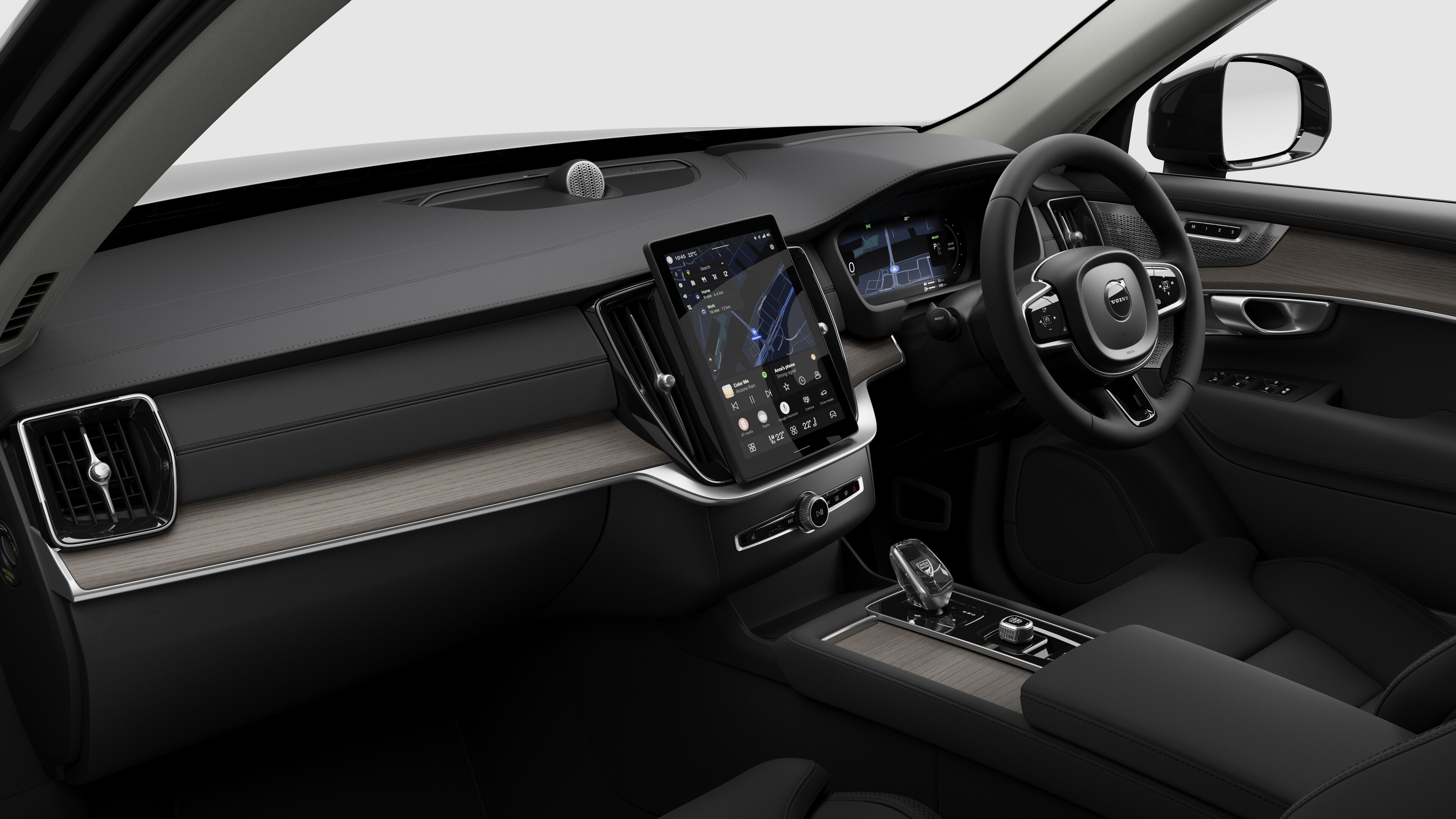 Interior view of a Volvo car showing the dashboard, steering wheel, center console, and digital display screen in a plain studio background.