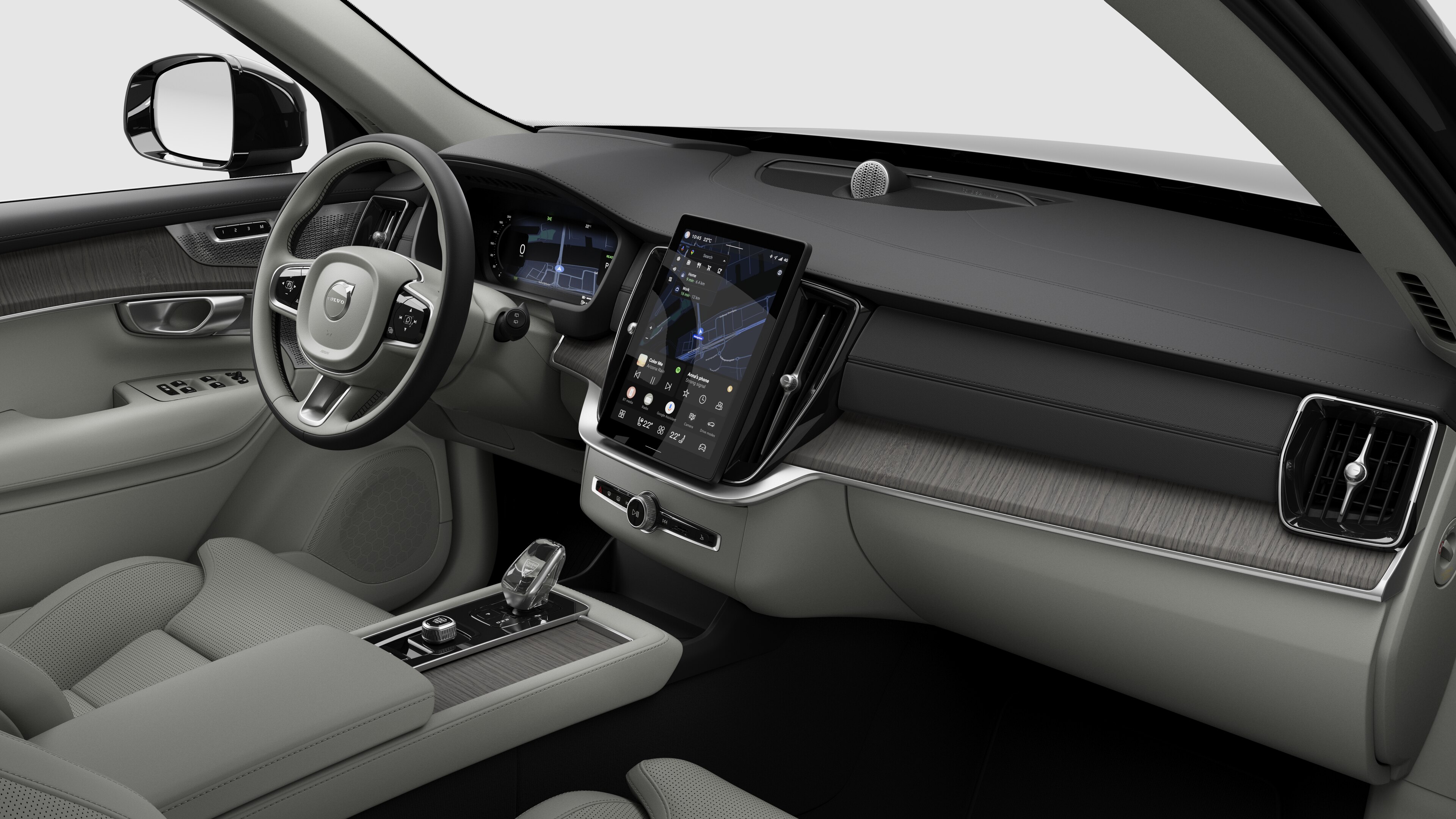 Vista interior de un vehículo Volvo que muestra el salpicadero, el volante, la consola central y la pantalla de visualización digital en un fondo de estudio liso.