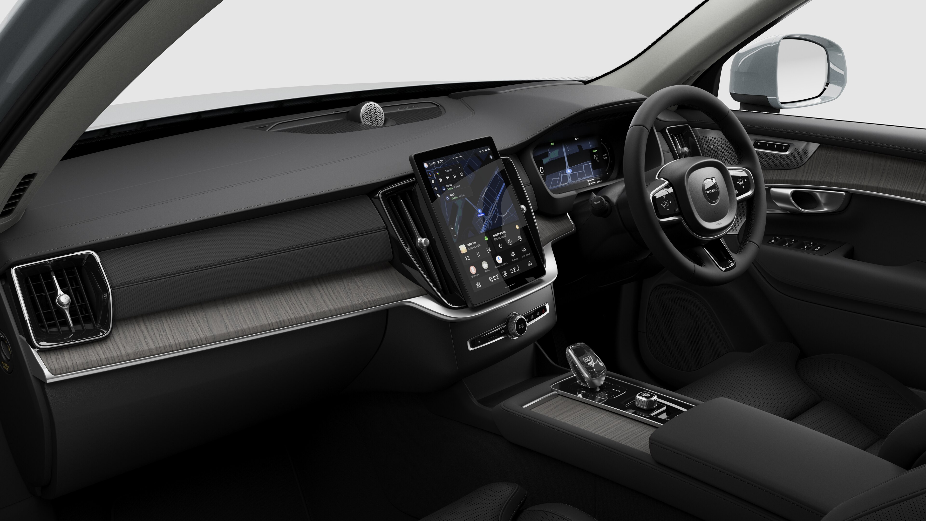 Interior view of a Volvo car showing the dashboard, steering wheel, center console, and digital display screen in a plain studio background.