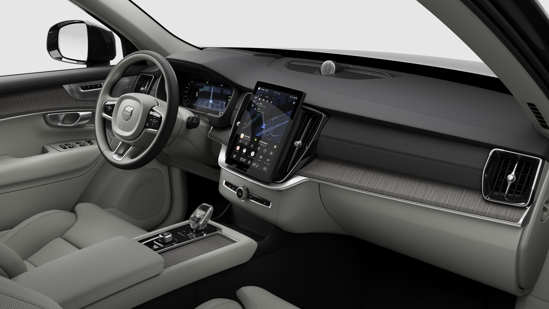 Vue intérieure d’une Volvo montrant le tableau de bord, le volant, la console centrale et l’écran d’affichage numérique sur un fond de studio uni.