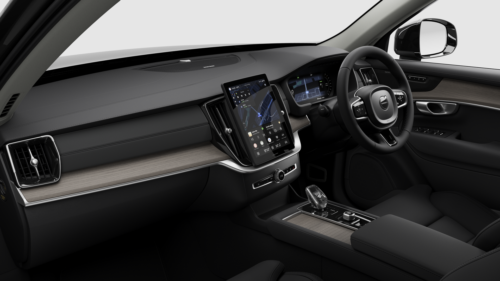 Interior view of a Volvo car showing the dashboard, steering wheel, center console, and digital display screen in a plain studio background.