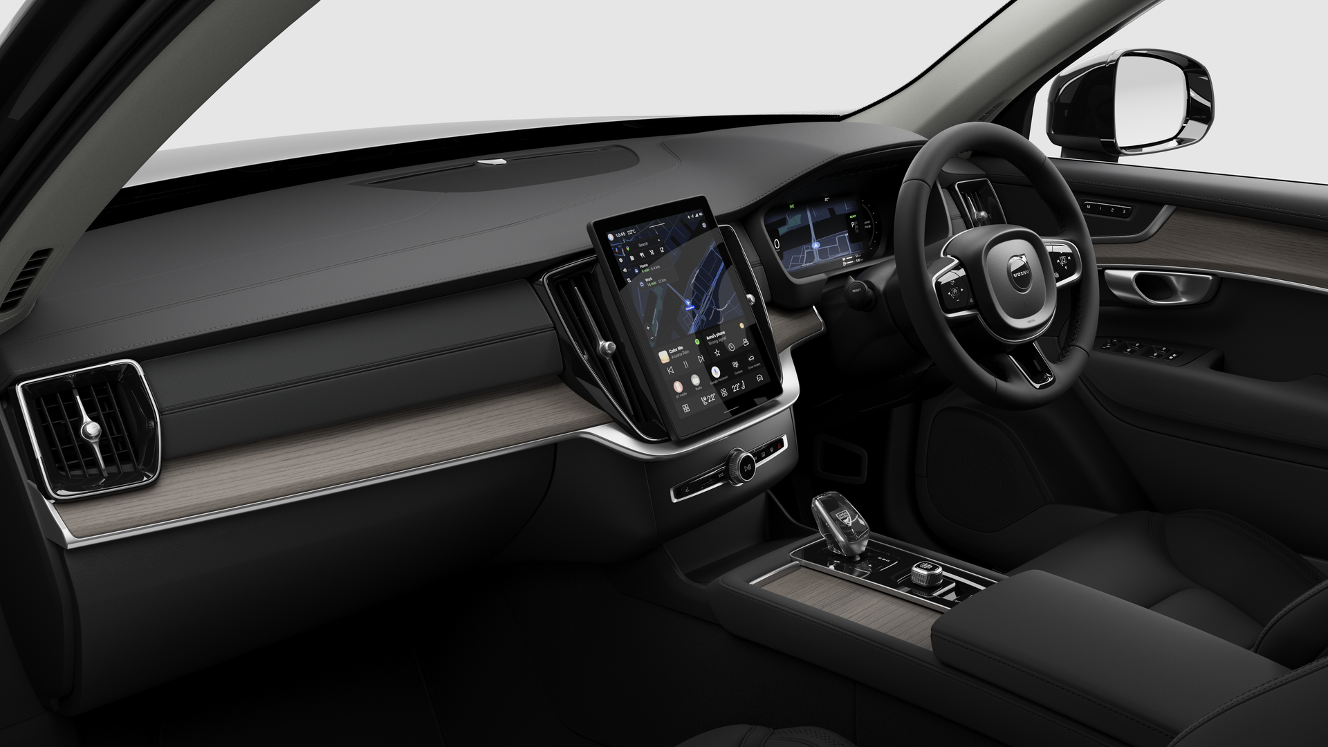 Interior view of a Volvo car showing the dashboard, steering wheel, center console, and digital display screen in a plain studio background.
