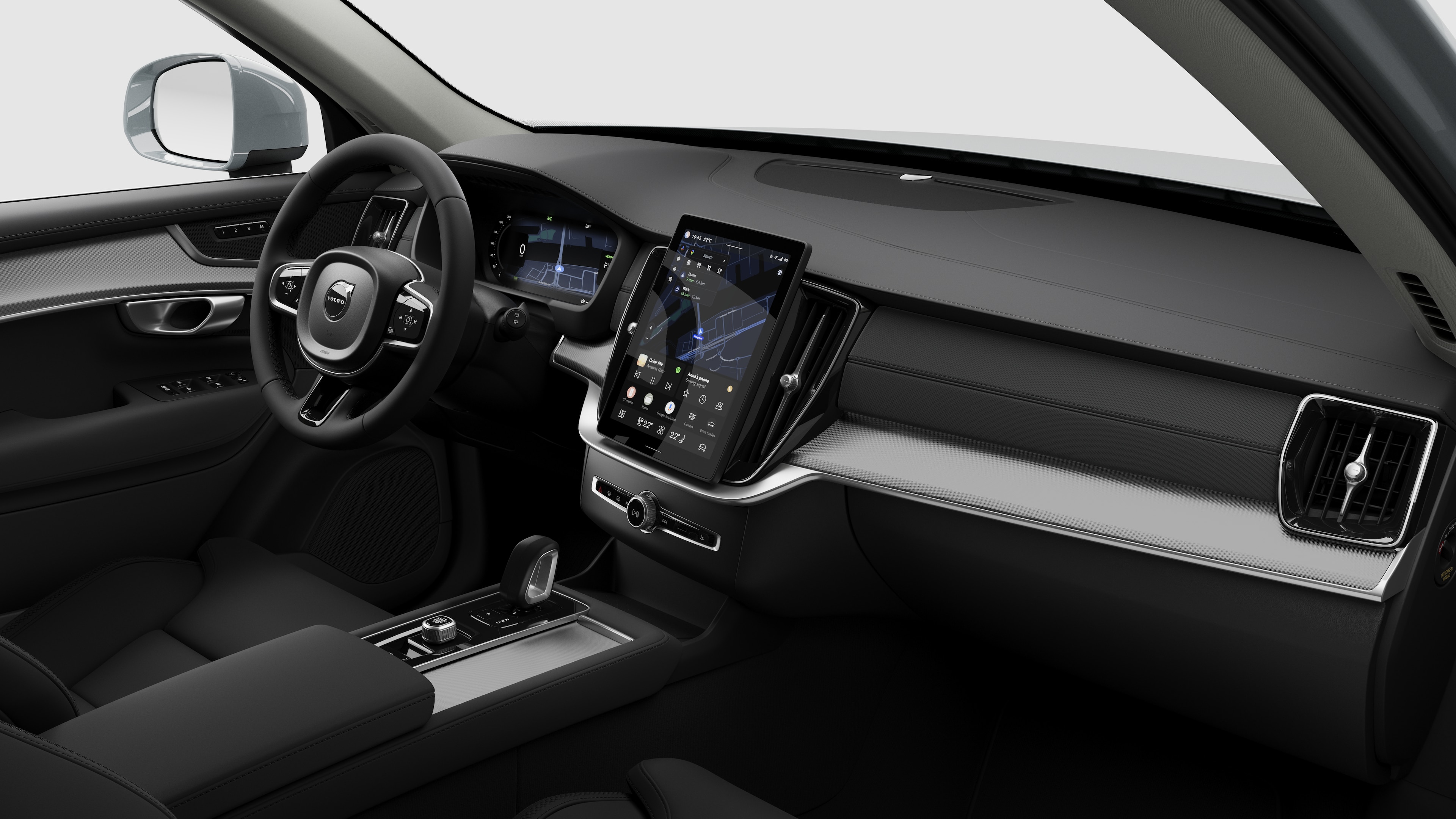 ვოლვოს მანქანის ინტერიერის ხედი, რომელიც აჩვენებს დაფას, საჭეს, ცენტრალურ კონსოლს და ციფრული დისპლეის ეკრანს სტუდიის უბრალო ფონზე.