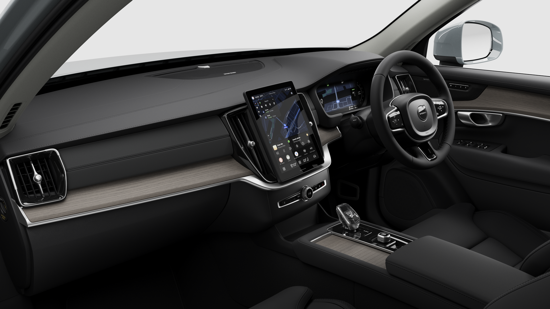 Interior view of a Volvo car showing the dashboard, steering wheel, center console, and digital display screen in a plain studio background.