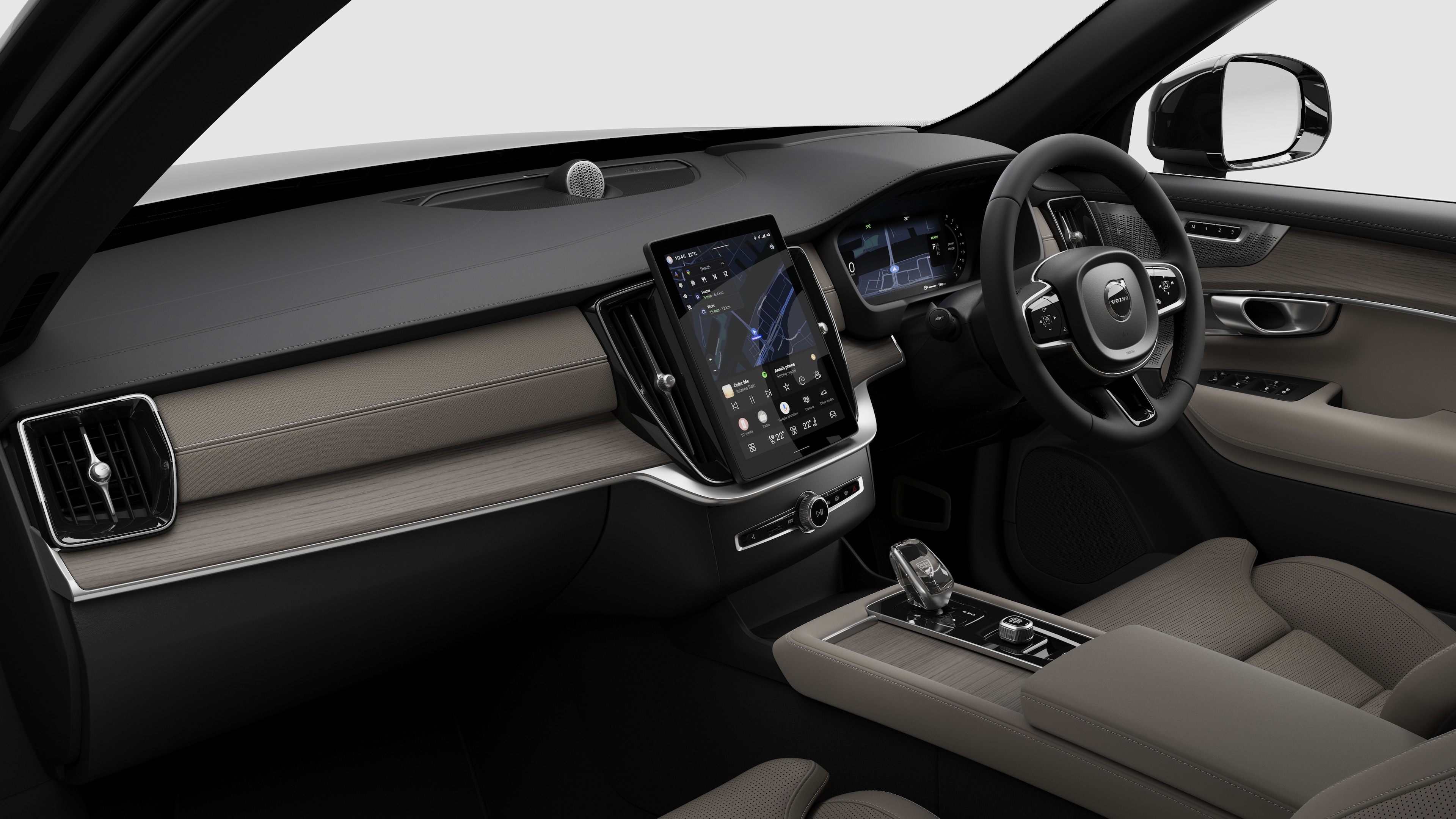 Interior view of a Volvo car showing the dashboard, steering wheel, center console, and digital display screen in a plain studio background.
