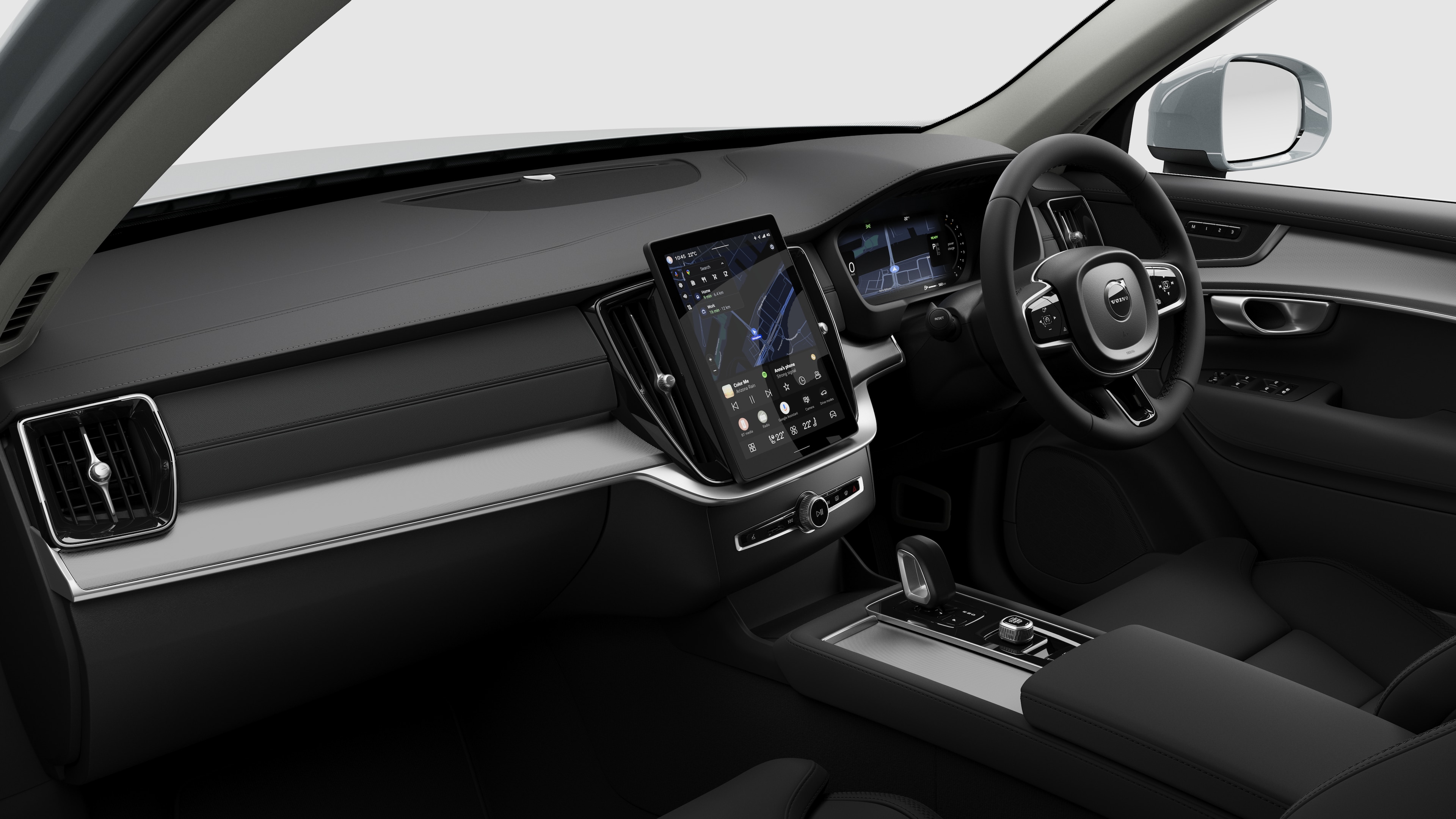 Interior view of a Volvo car showing the dashboard, steering wheel, center console, and digital display screen in a plain studio background.