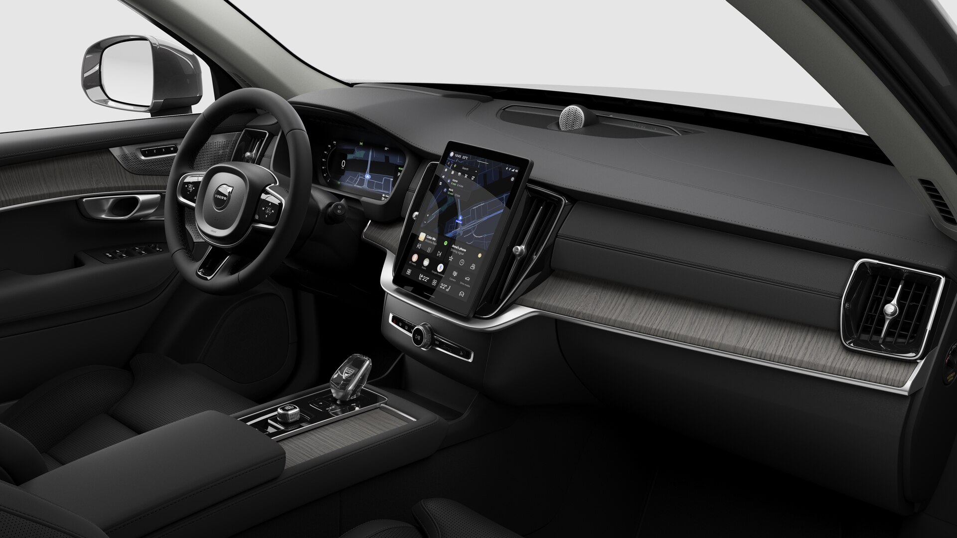 Vue intérieure d’une Volvo montrant le tableau de bord, le volant, la console centrale et l’écran d’affichage numérique sur un fond de studio uni.