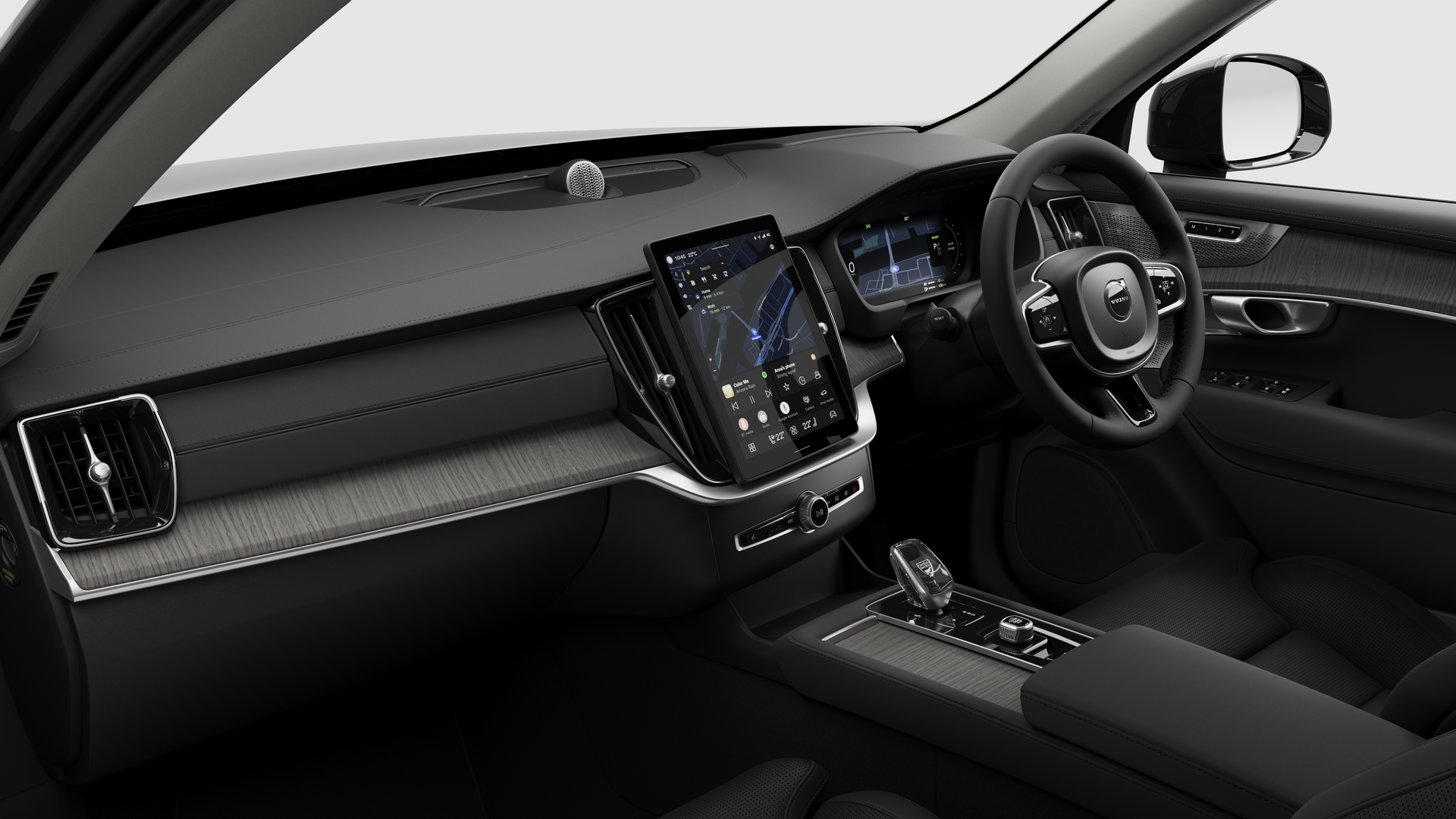 Interior view of a Volvo car showing the dashboard, steering wheel, center console, and digital display screen in a plain studio background.