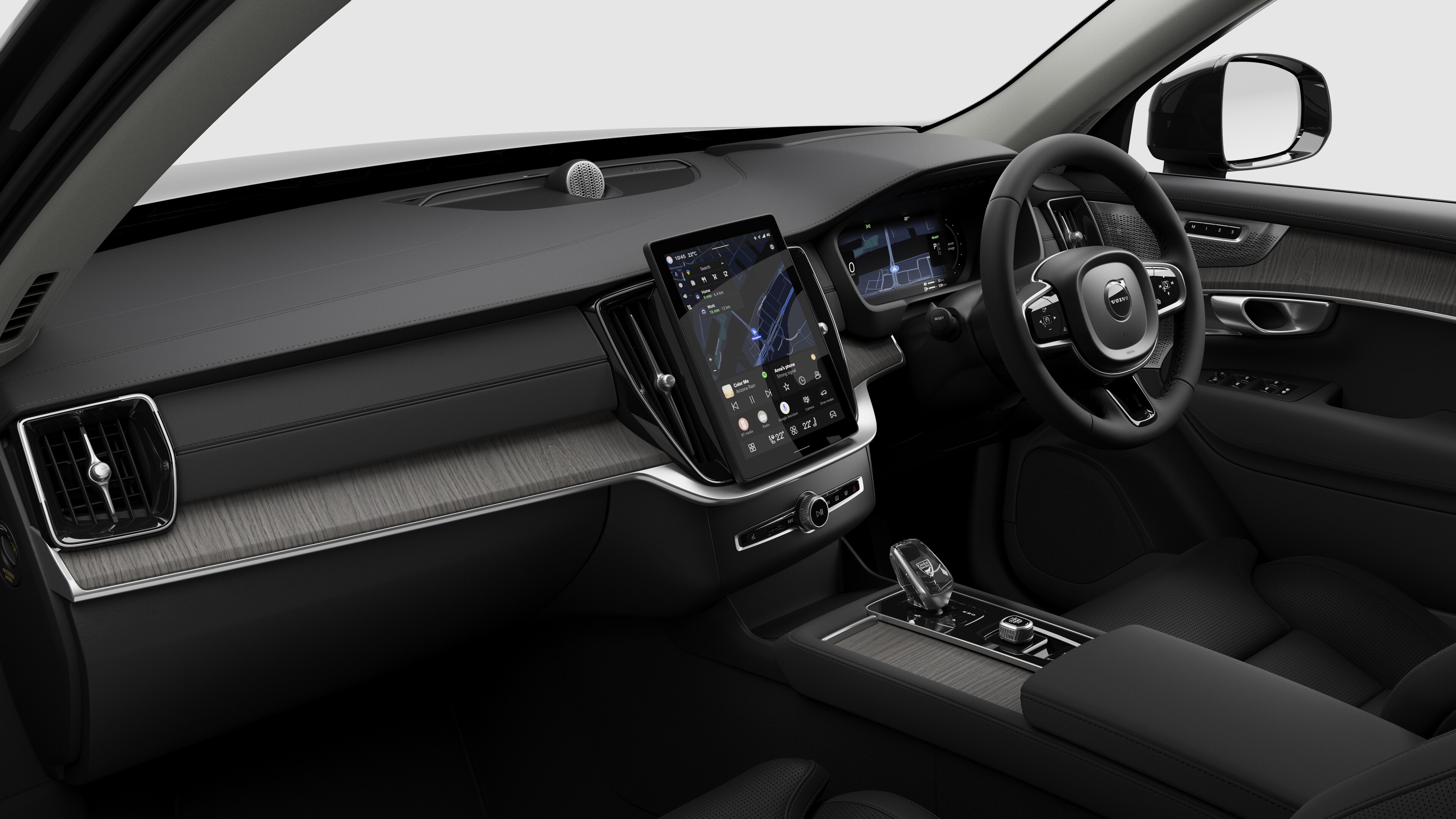 Interior view of a Volvo car showing the dashboard, steering wheel, center console, and digital display screen in a plain studio background.