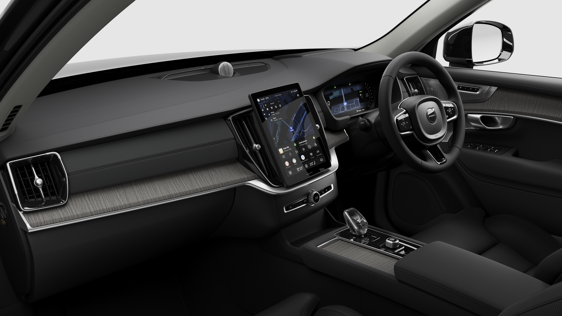Interior view of a Volvo car showing the dashboard, steering wheel, center console, and digital display screen in a plain studio background.