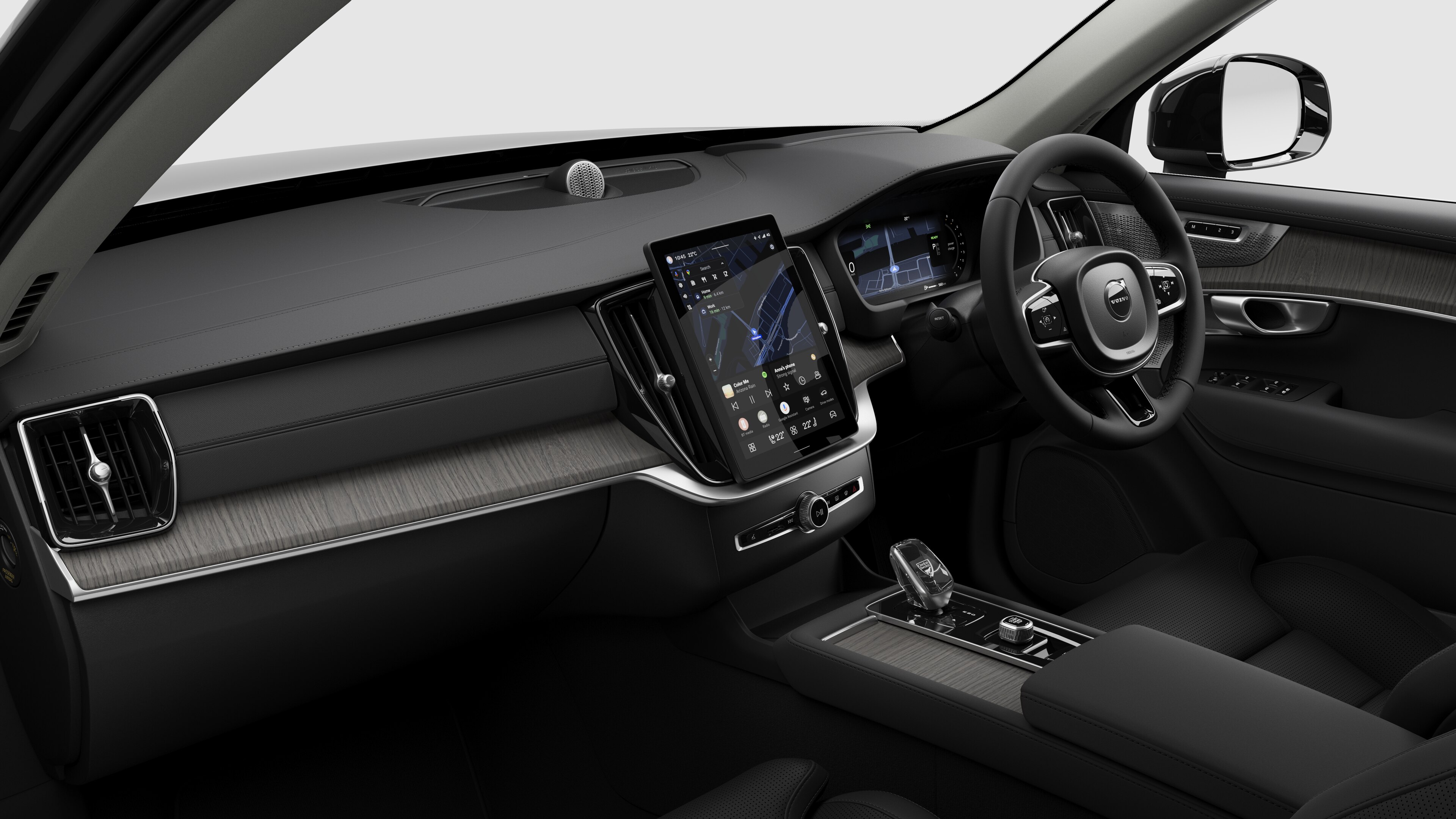 Interior view of a Volvo car showing the dashboard, steering wheel, center console, and digital display screen in a plain studio background.