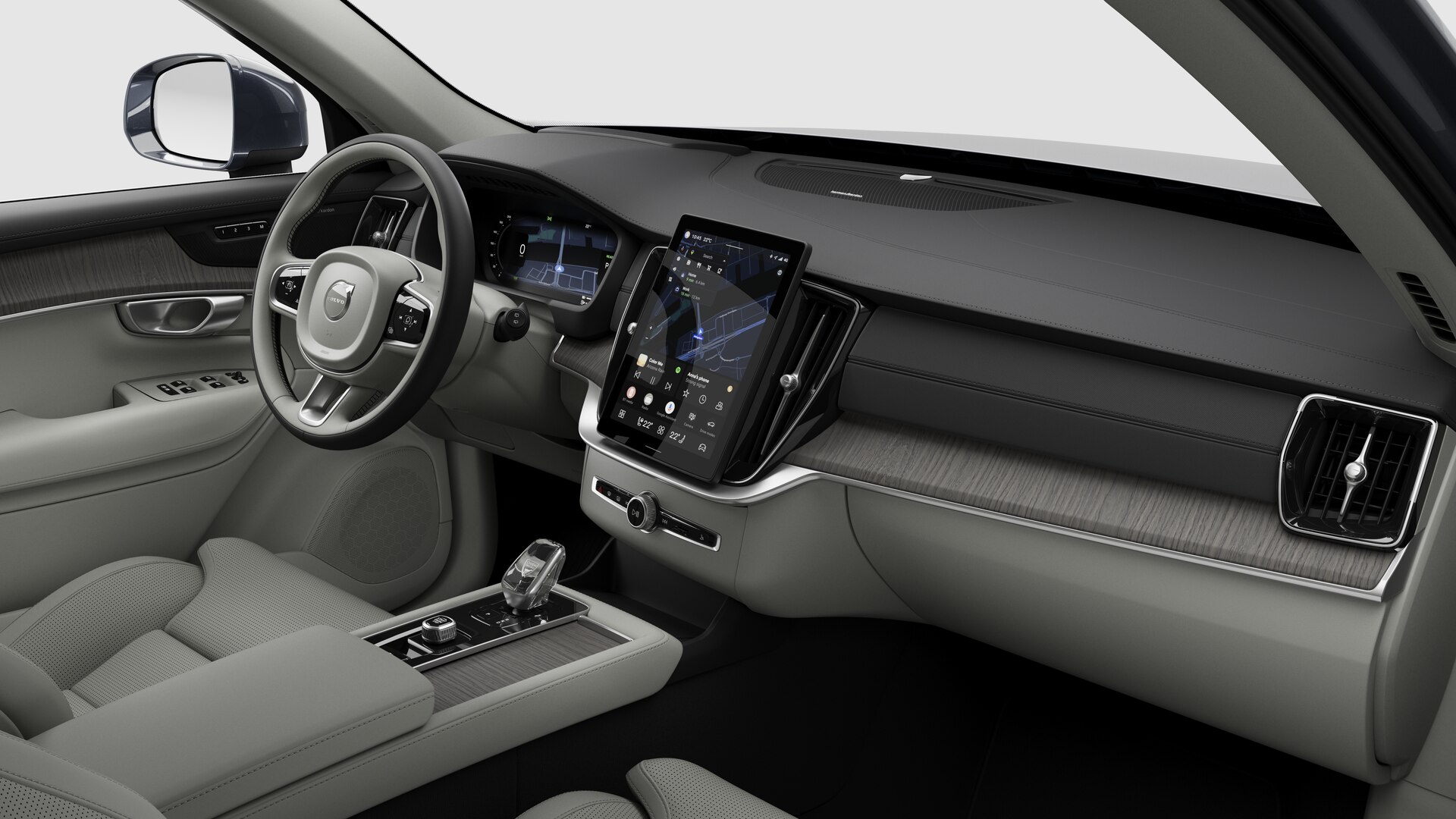 Vue intérieure d’une Volvo montrant le tableau de bord, le volant, la console centrale et l’écran d’affichage numérique sur un fond de studio uni.