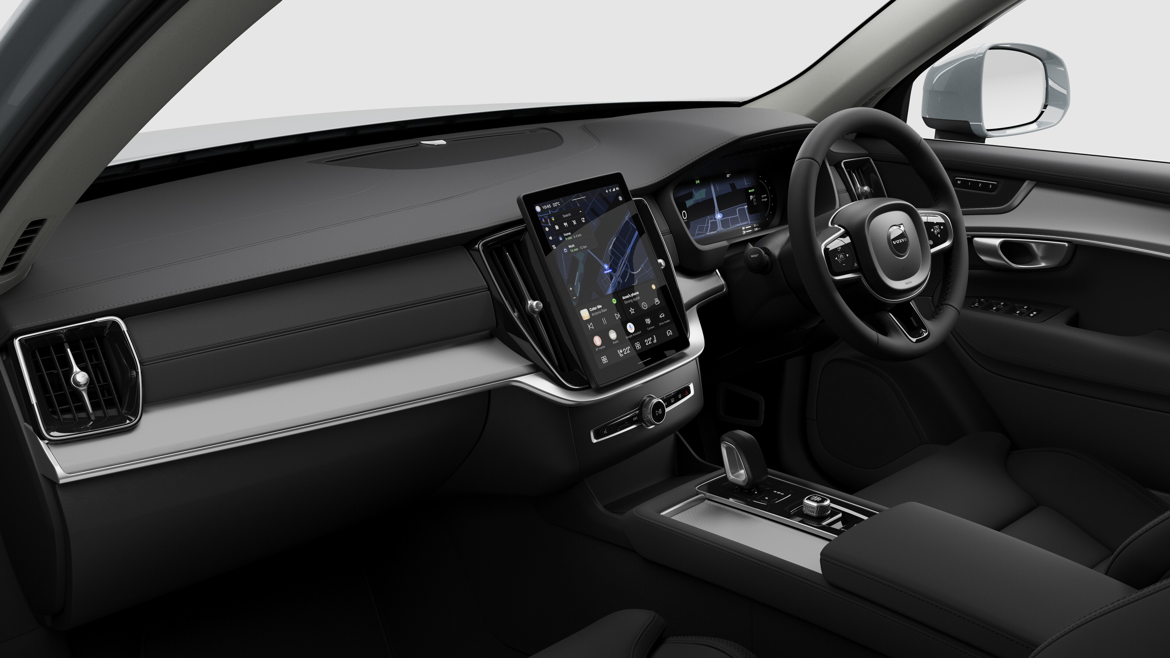 Interior view of a Volvo car showing the dashboard, steering wheel, center console, and digital display screen in a plain studio background.
