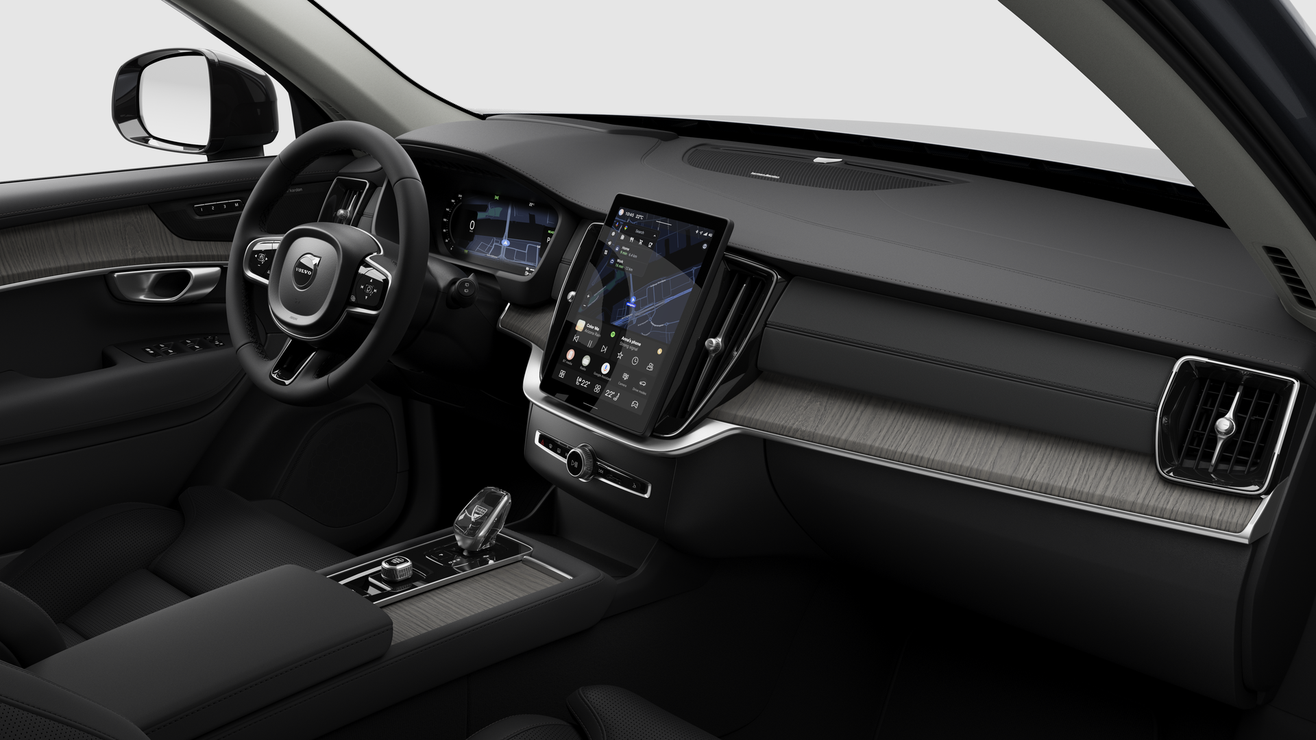 Vue intérieure d’une Volvo montrant le tableau de bord, le volant, la console centrale et l’écran d’affichage numérique sur un fond de studio uni.