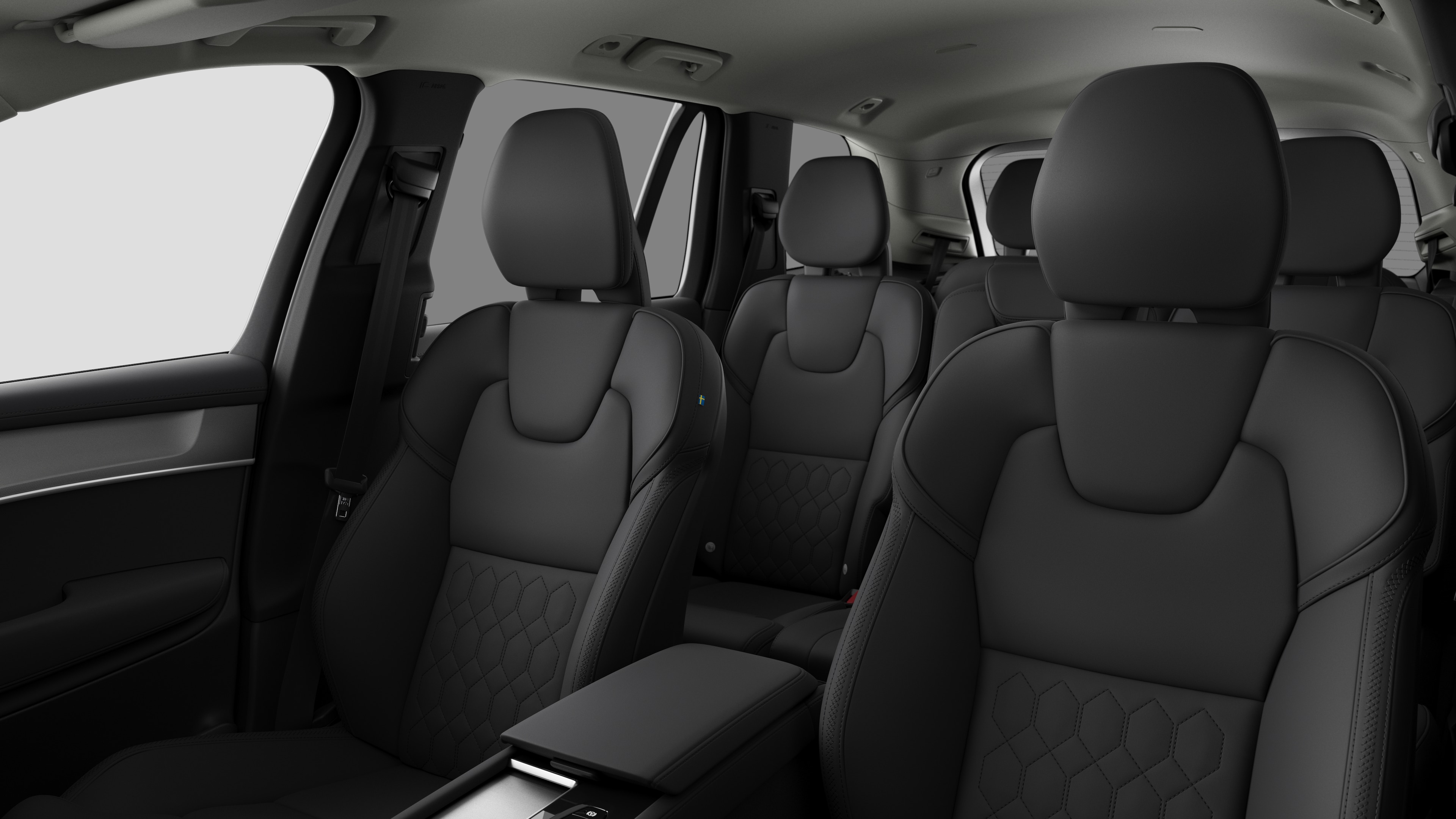 Volvo მანქანის ინტერიერი, რომელიც აჩვენებს უკანა სამგზავრო სავარძლებს და ცენტრალურ კონსოლს უბრალო სტუდიის ფონზე.