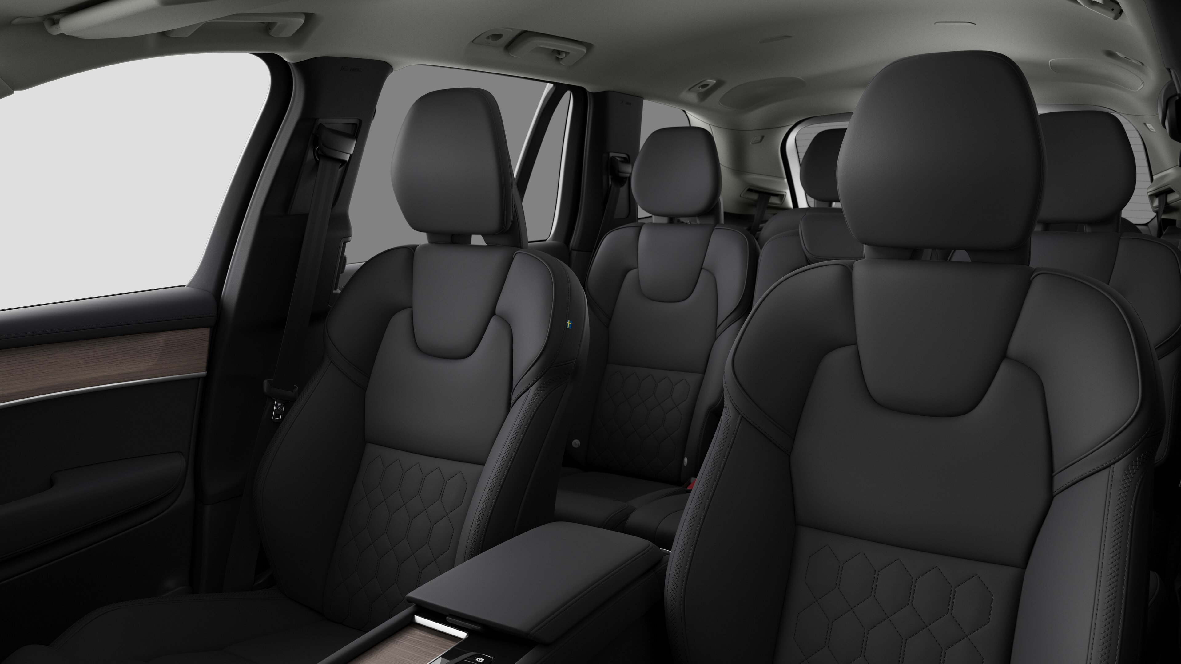 Volvo avtomobil interyerində arxa sərnişin oturacaqları və sadə studiya fonunda mərkəz konsolu göstərilir.