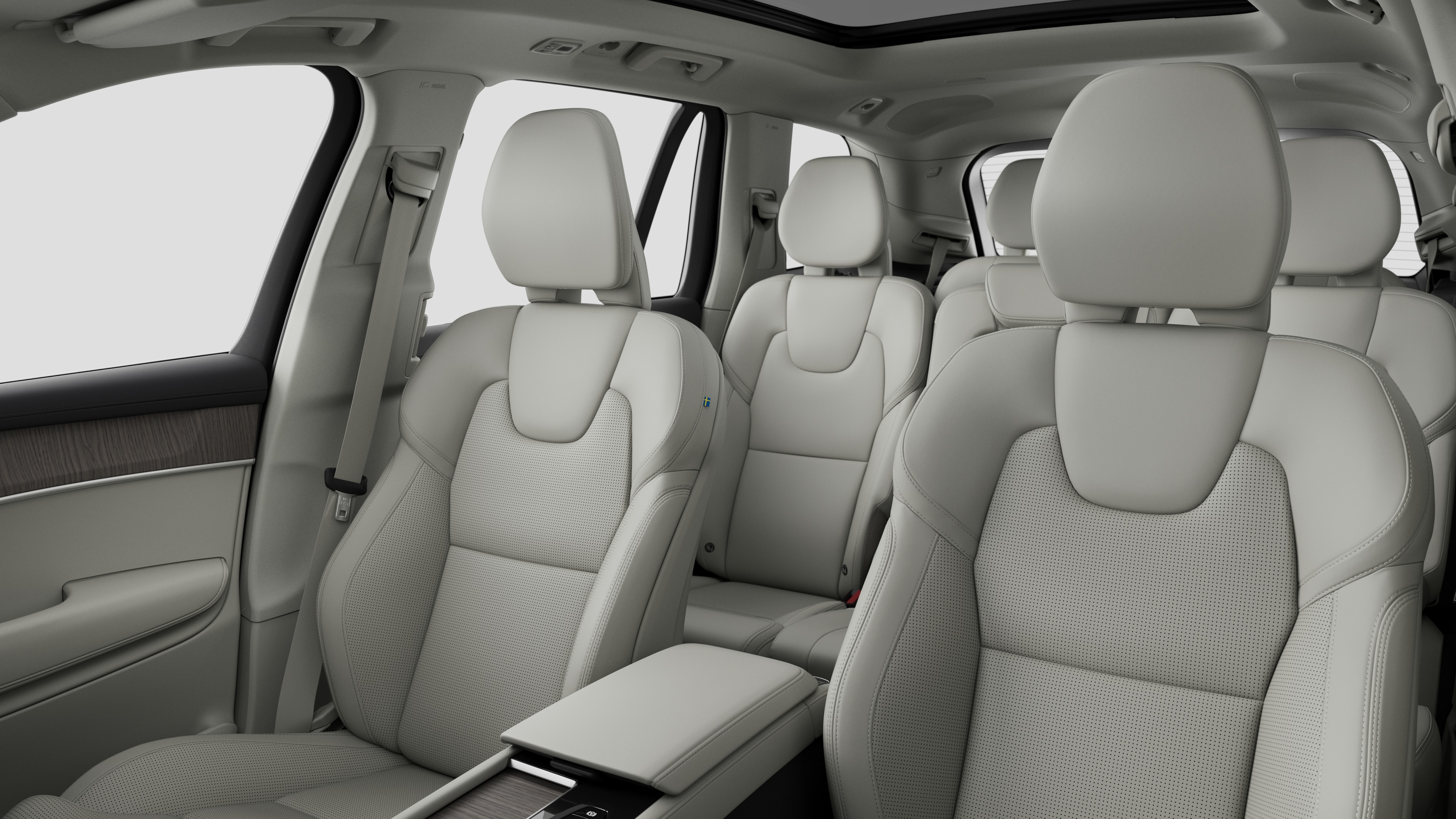 Interior del vehículo Volvo que muestra los asientos traseros del pasajero y la consola central en un fondo de estudio liso.