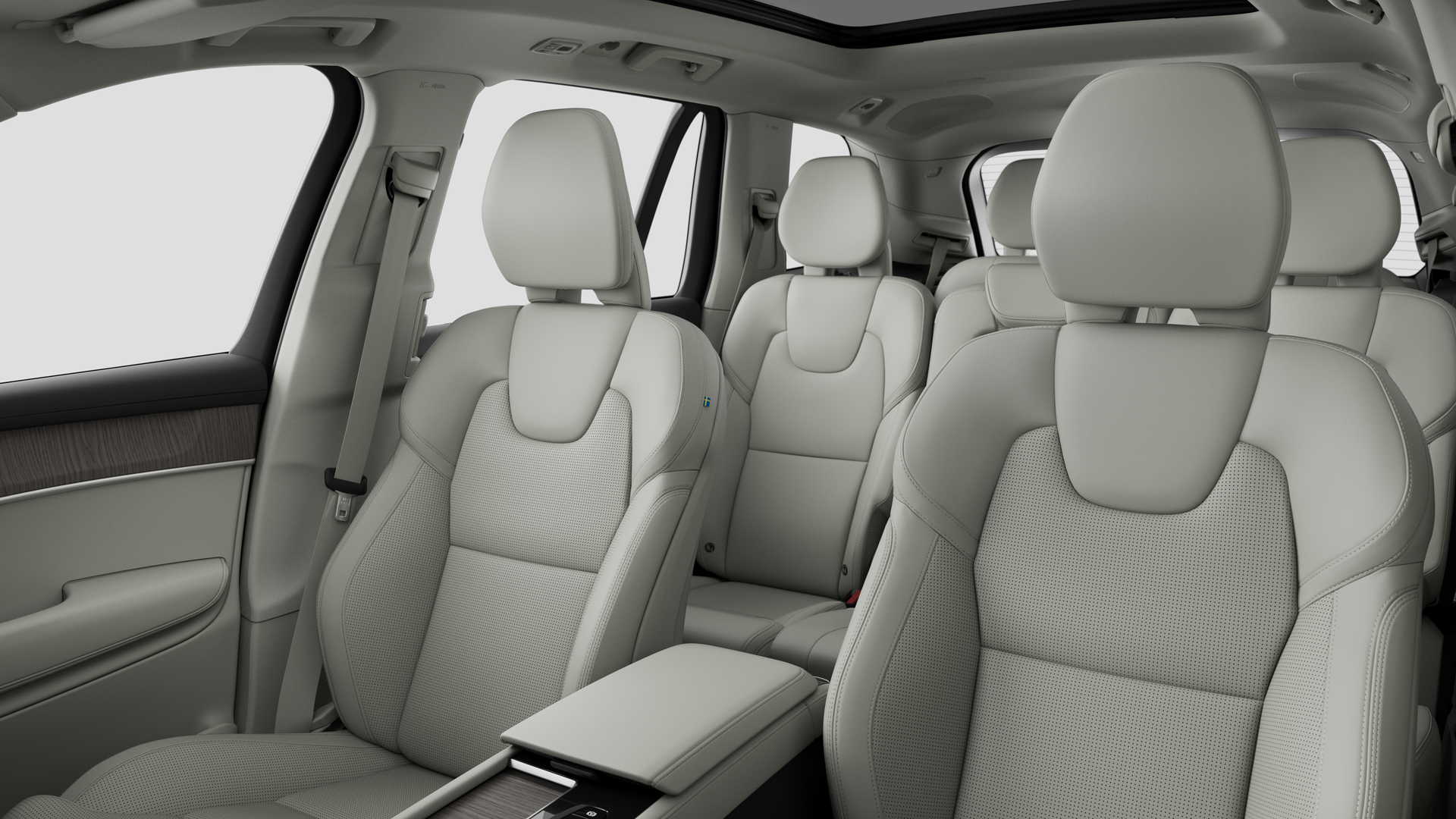 Interior del vehículo Volvo que muestra los asientos traseros del pasajero y la consola central en un fondo de estudio liso.