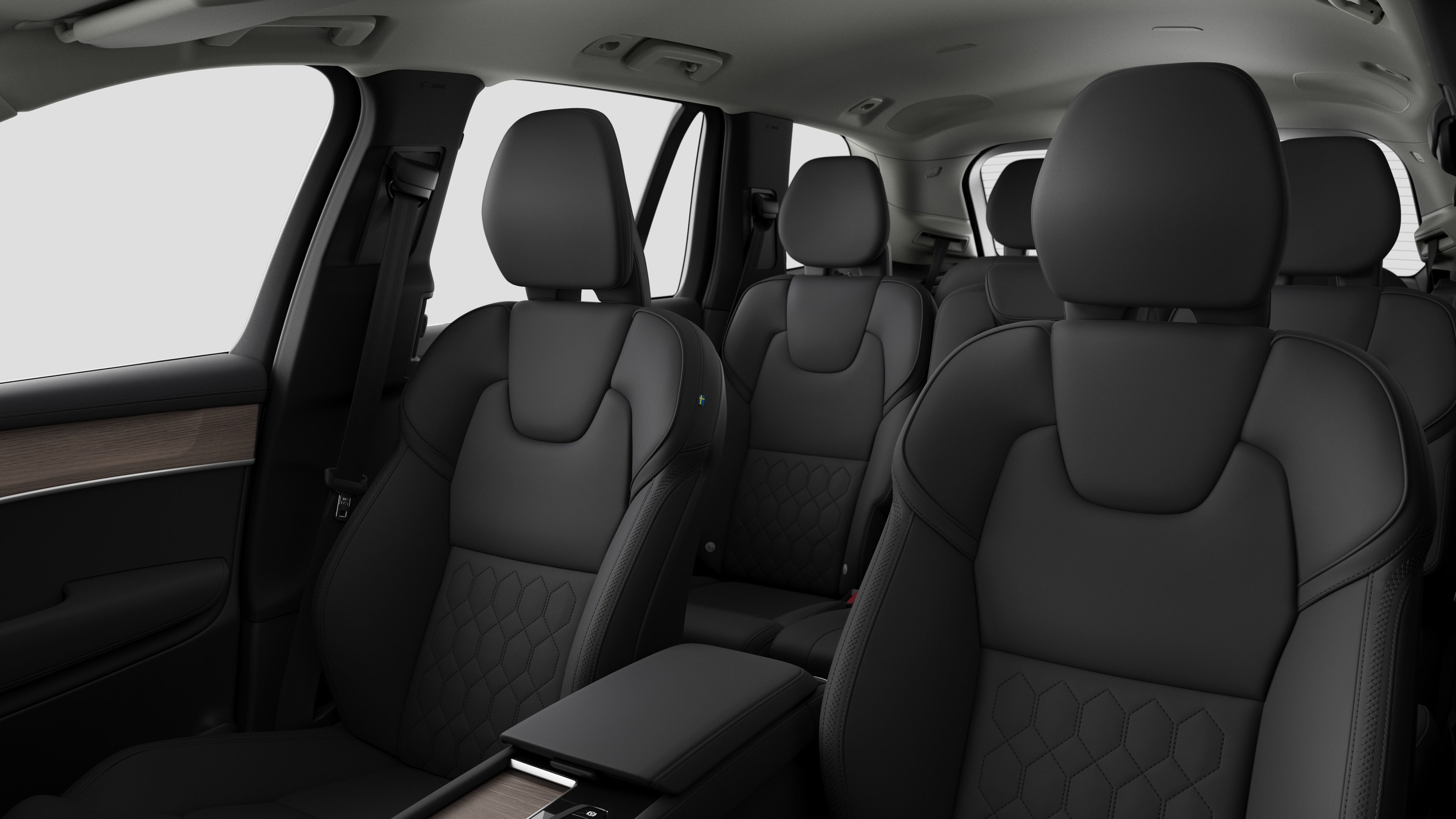 Volvo automašīnas salons ar aizmugurējo pasažieru sēdekļiem un centrālo konsoli vienkāršā studijas fonā.