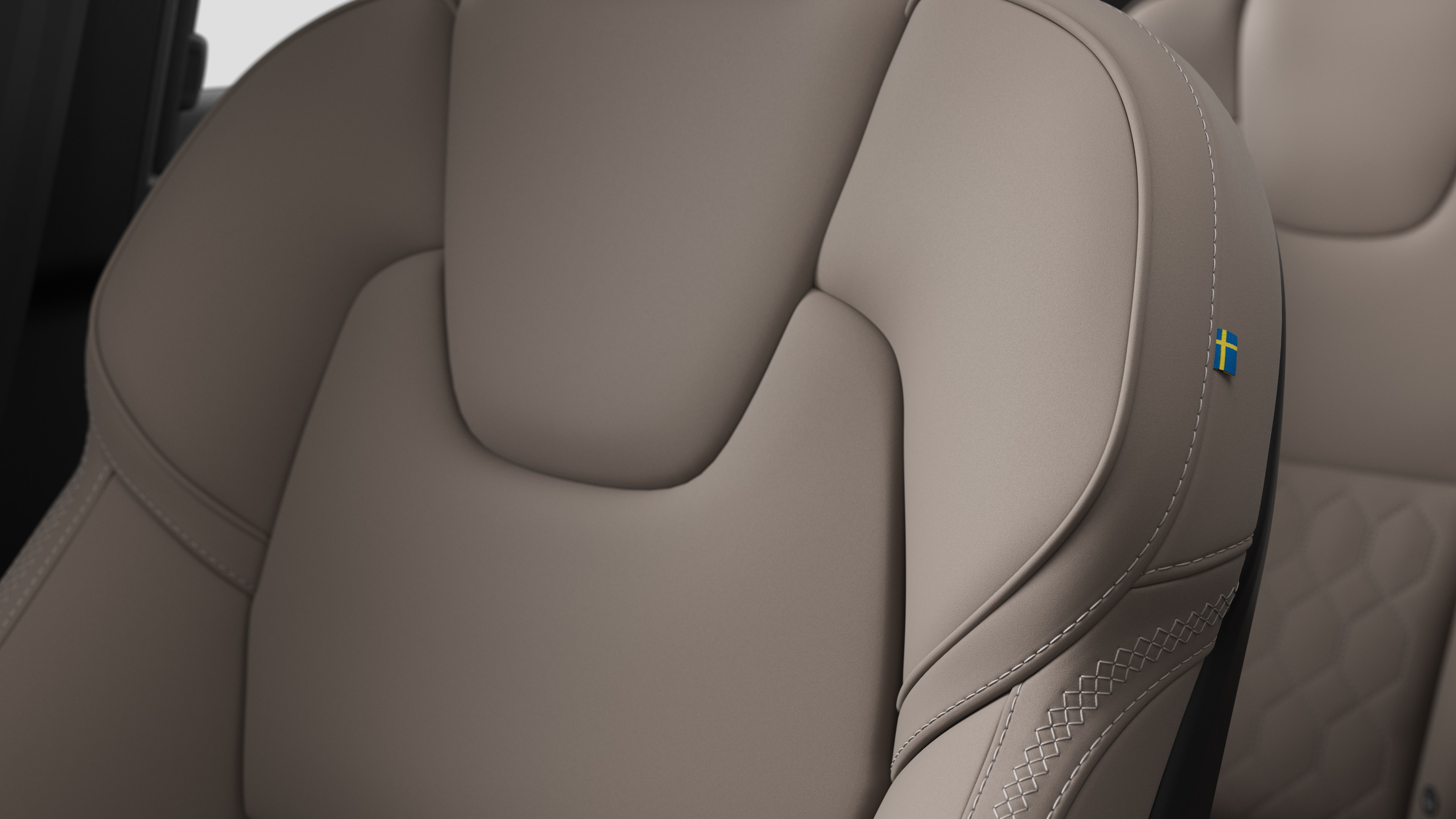 스티칭과 작은 스웨덴 국기 태그를 보여주는 볼보 자동차 내부 시트 디테일 클로즈업.