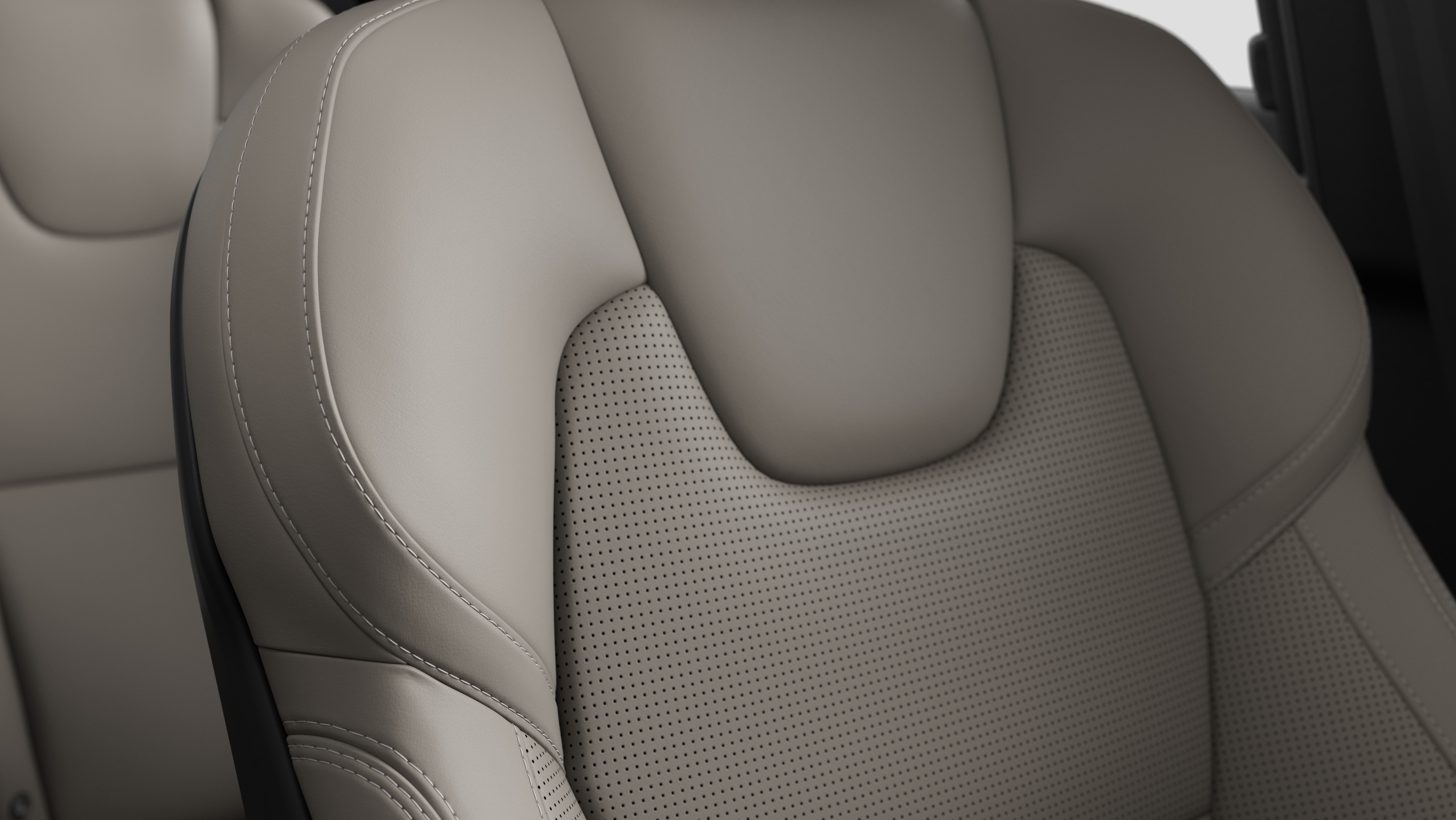 Close-up of Volvo car interior seat detail showing stitching and a small Swedish flag tag.