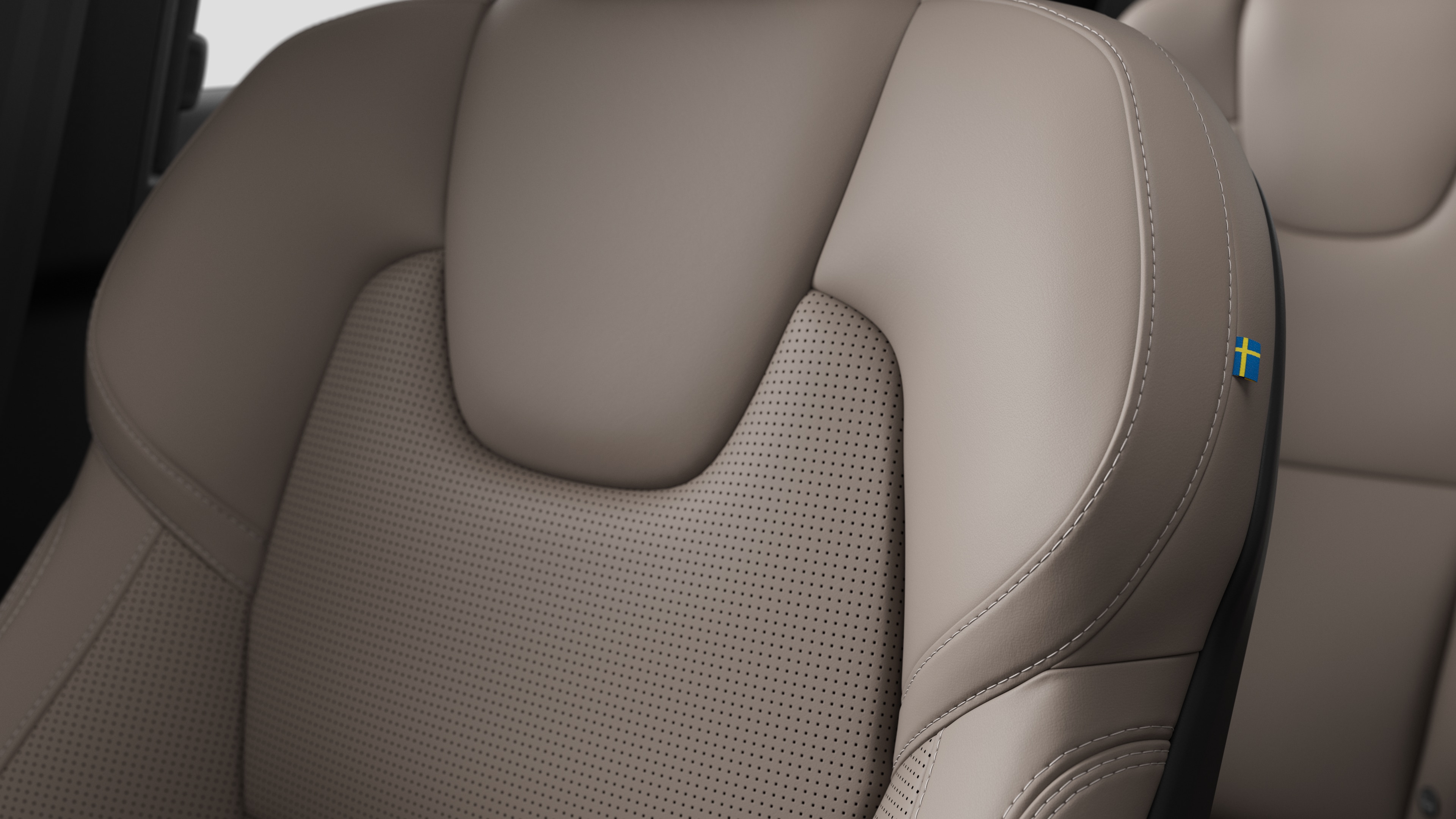 스티칭과 작은 스웨덴 국기 태그를 보여주는 볼보 자동차 내부 시트 디테일 클로즈업.