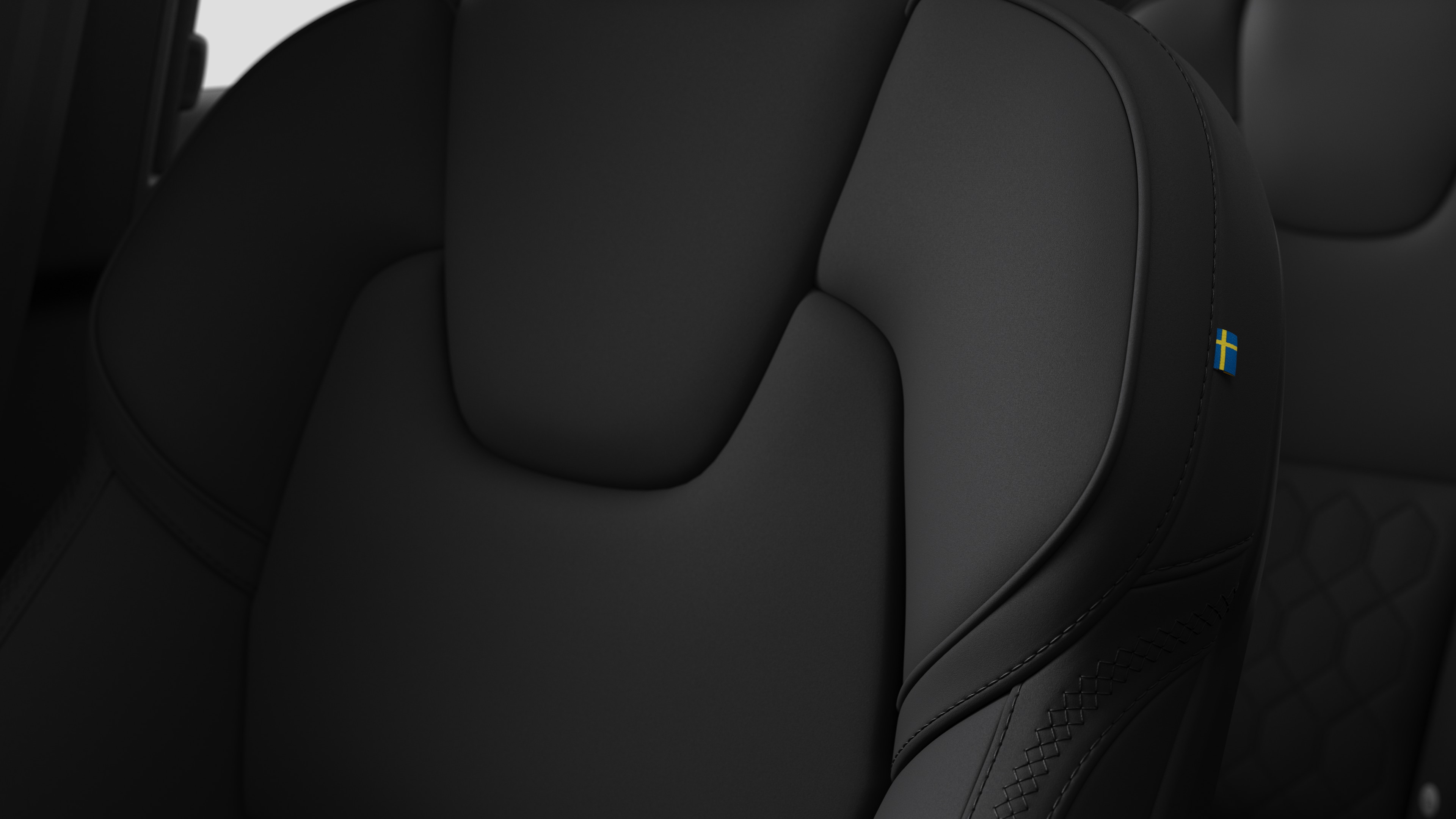 Bližnji pogled na podrobnosti notranjosti avtomobila Volvo s šivi in majhno švedsko zastavo.