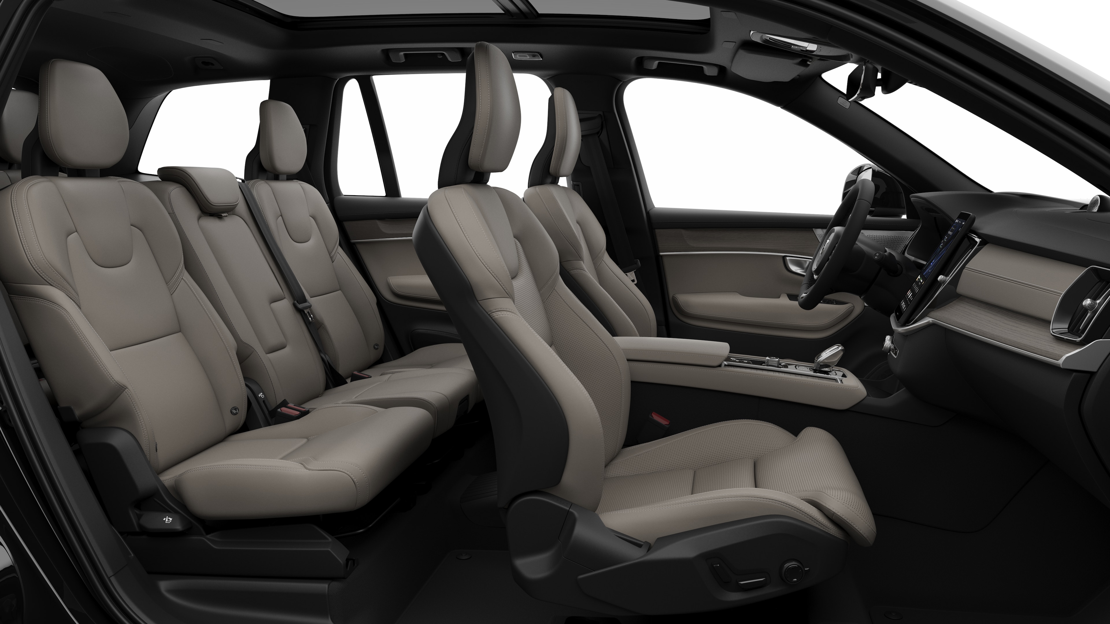 Vista lateral do interior do carro Volvo mostrando os bancos dianteiros, traseiros do passageiro, volante, painel de instrumentos e console central, contra um plano de fundo de estúdio simples.