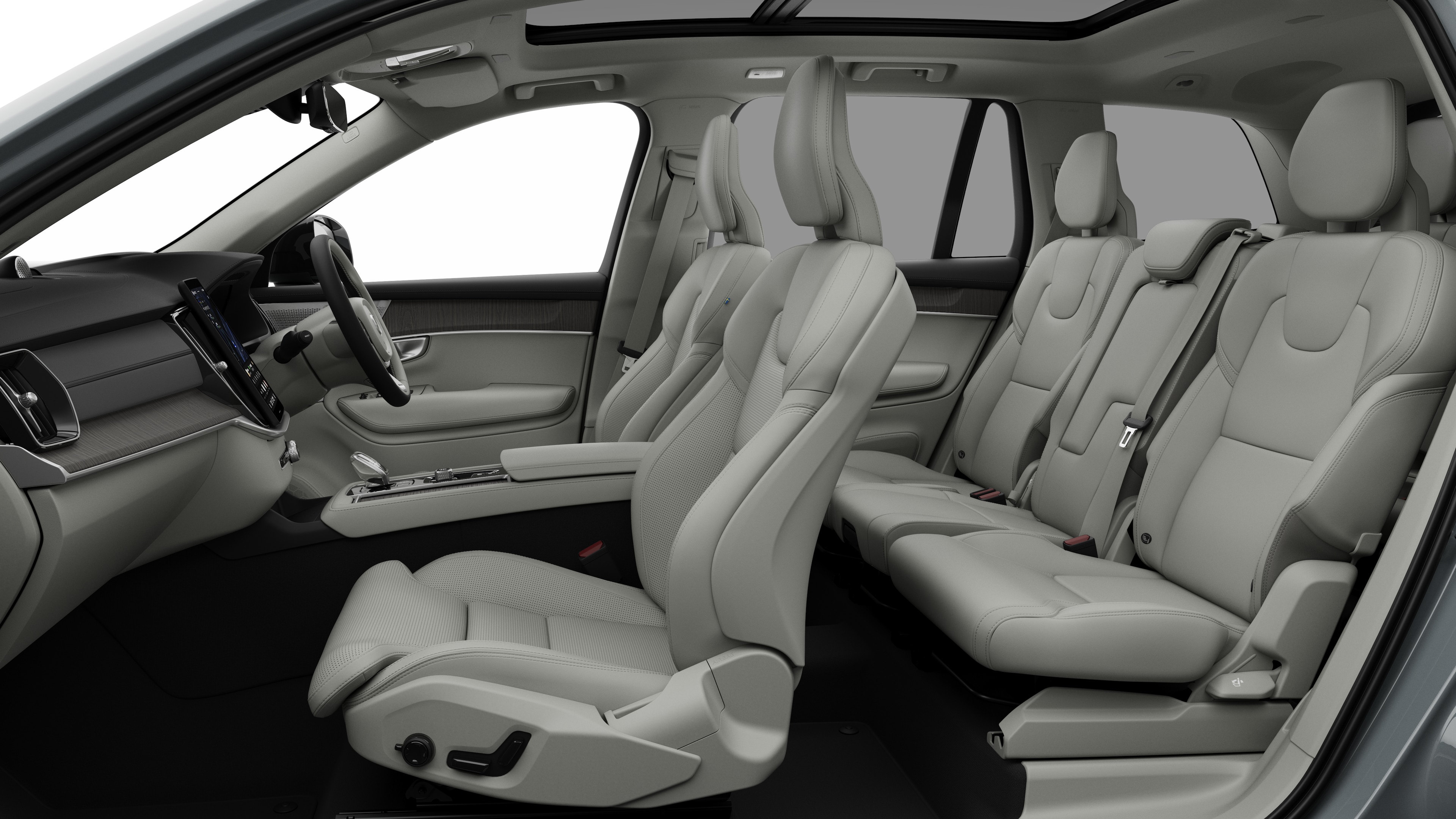 Volvo car interior side view showcasing front seats, rear passenger seats, steering wheel, dashboard, and center console, set against plain studio background.