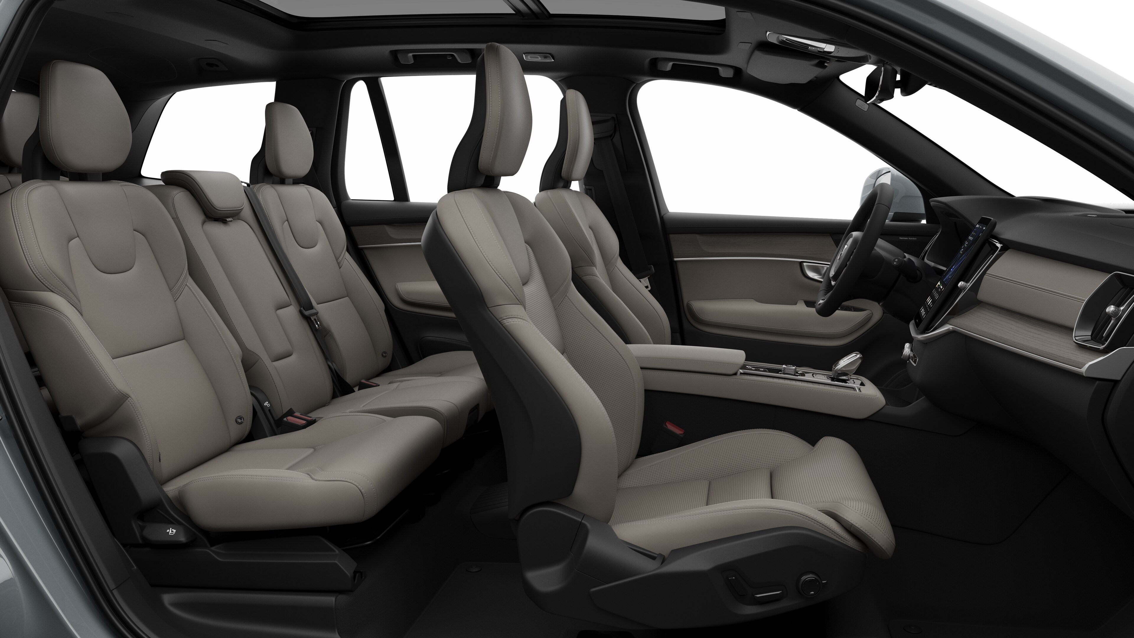 Volvo-bilens interiør set fra siden med forsæder, passagersæder bagi, rat, instrumentbræt og midterkonsol mod almindelig studiebaggrund.