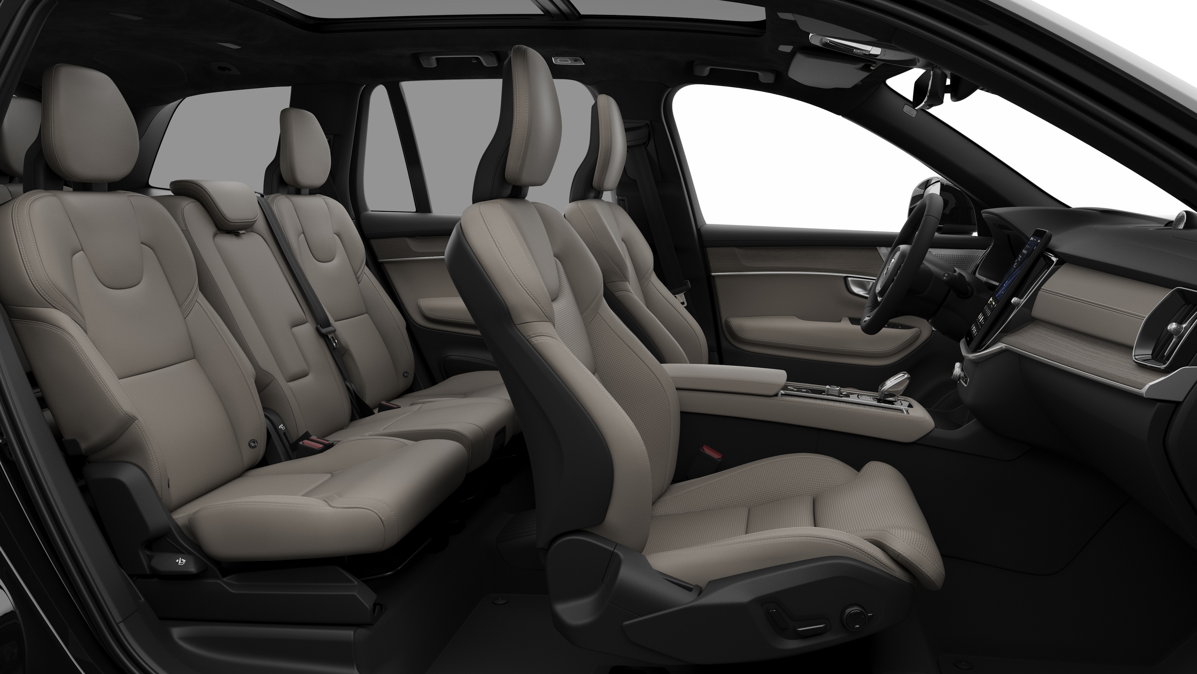 Seitenansicht des Innenraums eines Volvo Fahrzeugs mit Vordersitzen, Beifahrersitzen, Lenkrad, Armaturenbrett und Mittelkonsole vor einem schlichten Studiohintergrund.