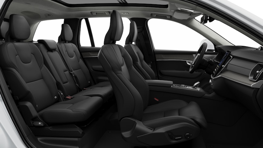 A Volvo autó belső oldalnézete az első ülésekkel, a hátsó utasülésekkel, a kormánykerékkel, a műszerfallal és a középkonzollal, egyszerű stúdió háttér előtt.