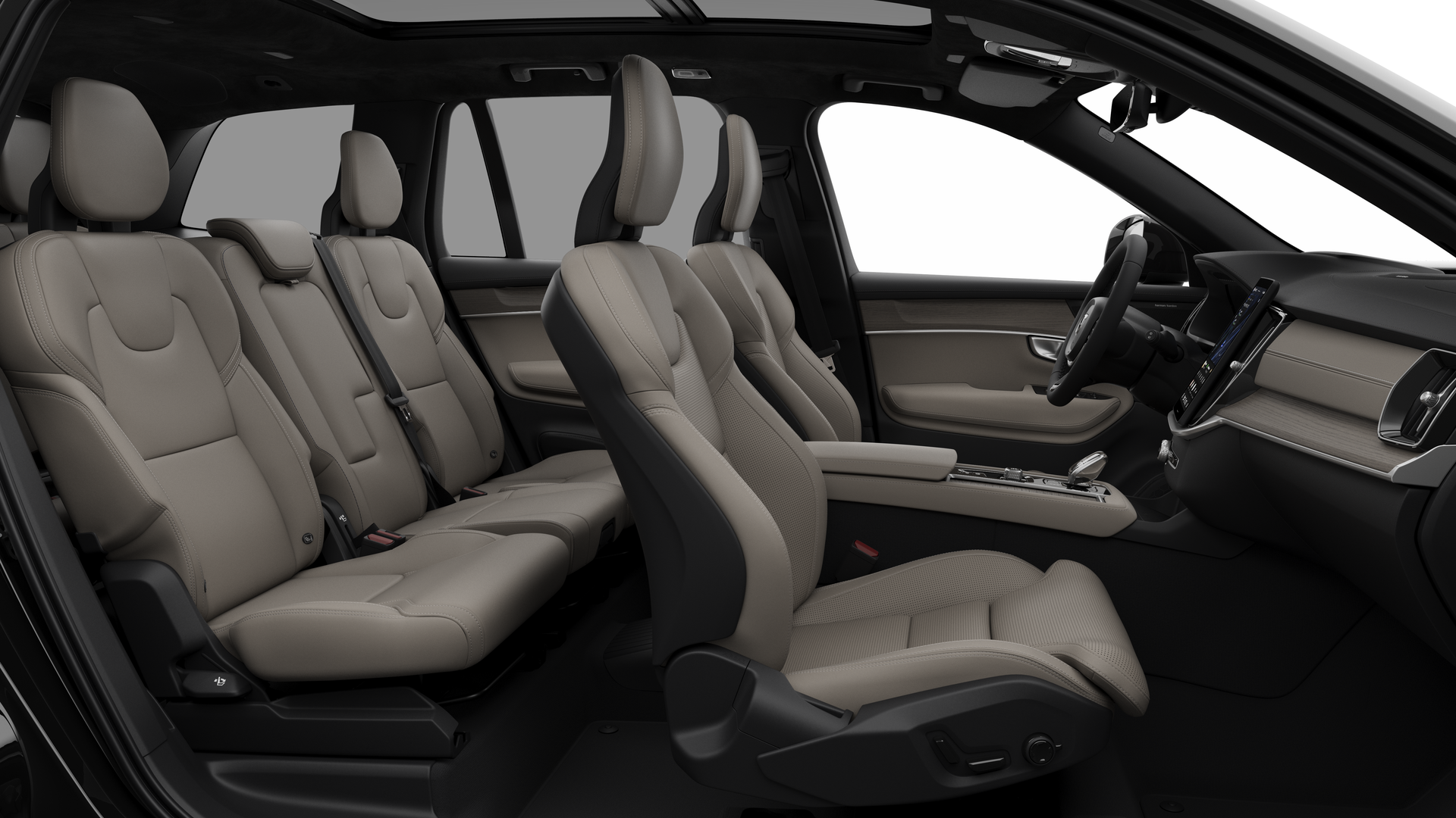 Vue latérale de l’intérieur d’une Volvo montrant les sièges avant, les sièges passager arrière, le volant, le tableau de bord et la console centrale, sur fond de studio.