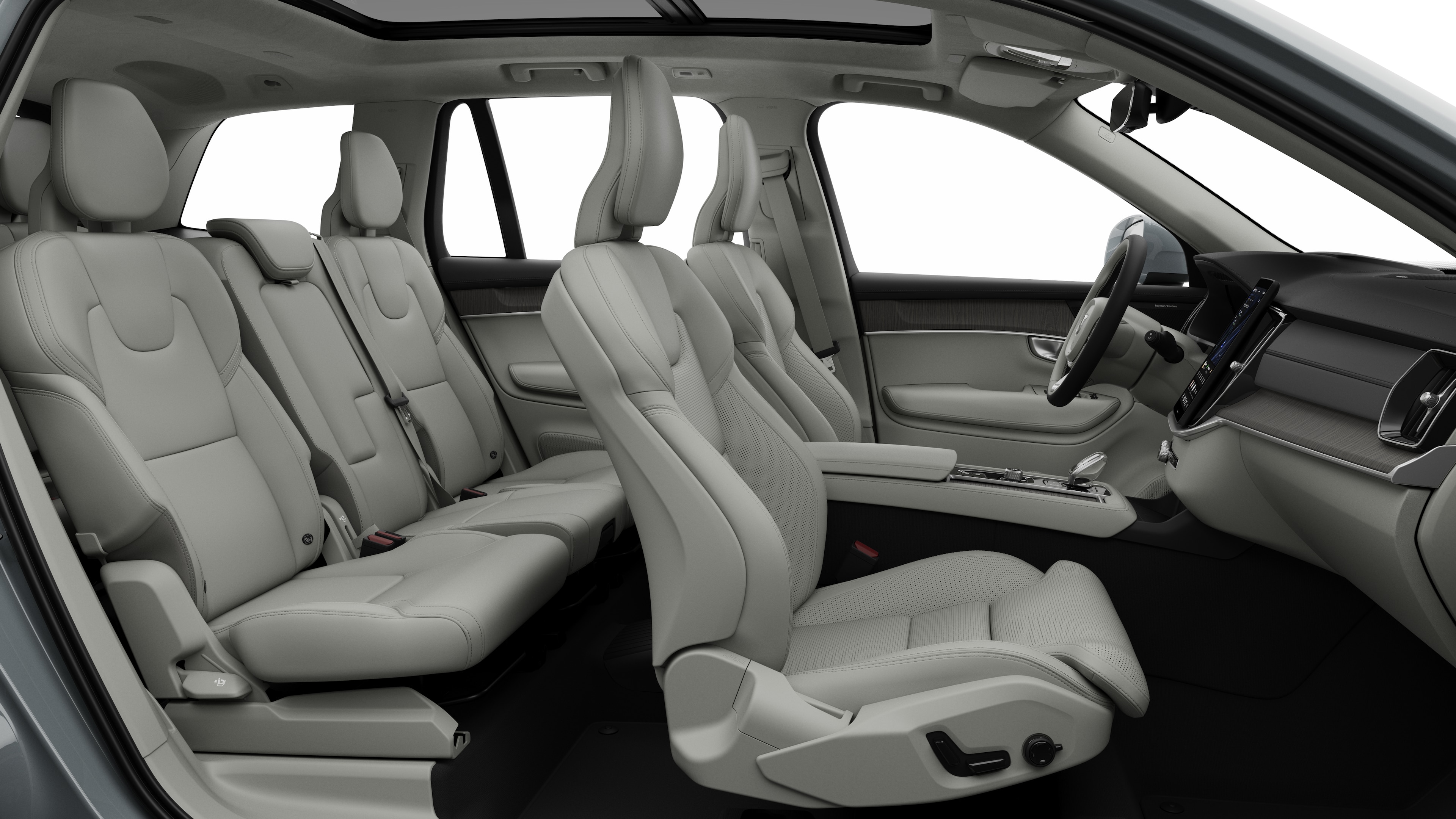 Vista laterale interna di un'auto Volvo che mostra i sedili anteriori, i sedili posteriori, il volante, il cruscotto e la console centrale, sullo sfondo di uno studio semplice.