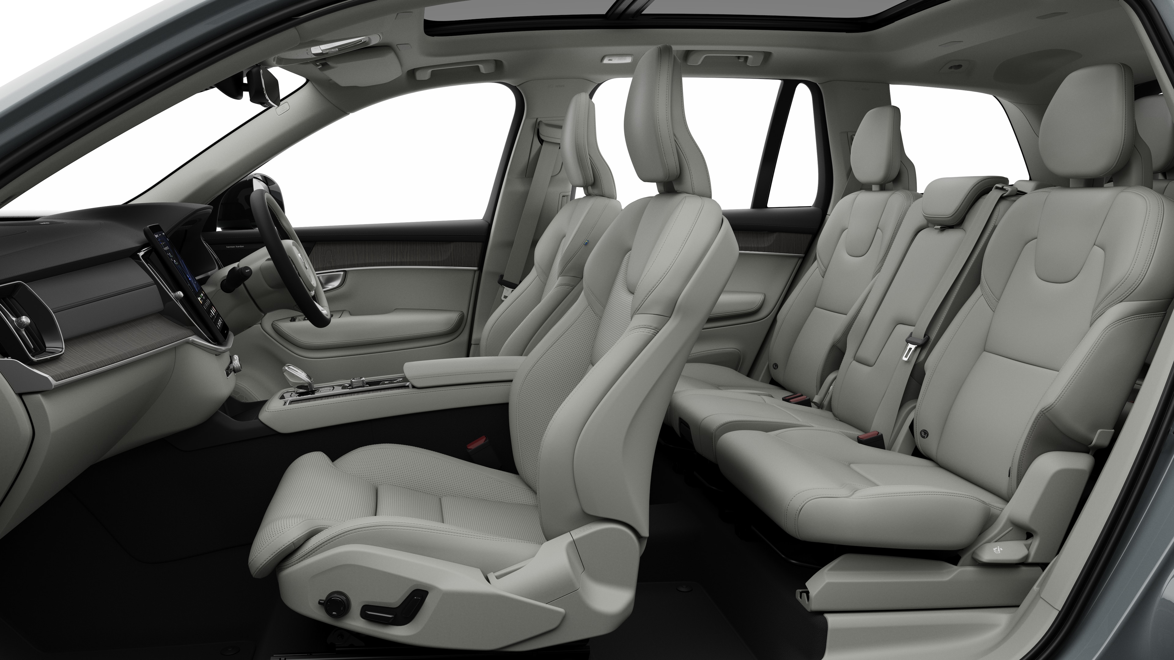 Volvo car interior side view showcasing front seats, rear passenger seats, steering wheel, dashboard, and center console, set against plain studio background.