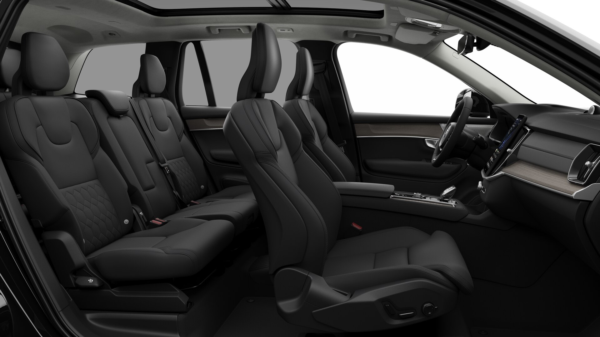 Vue latérale de l’intérieur d’une Volvo montrant les sièges avant, les sièges passager arrière, le volant, le tableau de bord et la console centrale, sur fond de studio.