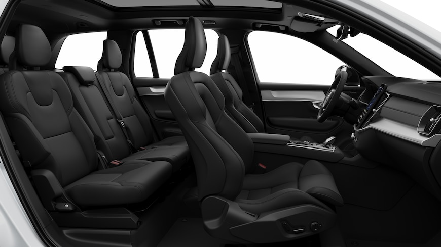 Vista lateral del interior de un coche Volvo en la que se ven los asientos delanteros, los asientos del pasajero trasero, el volante, el salpicadero y la consola central, sobre un fondo de estudio liso.