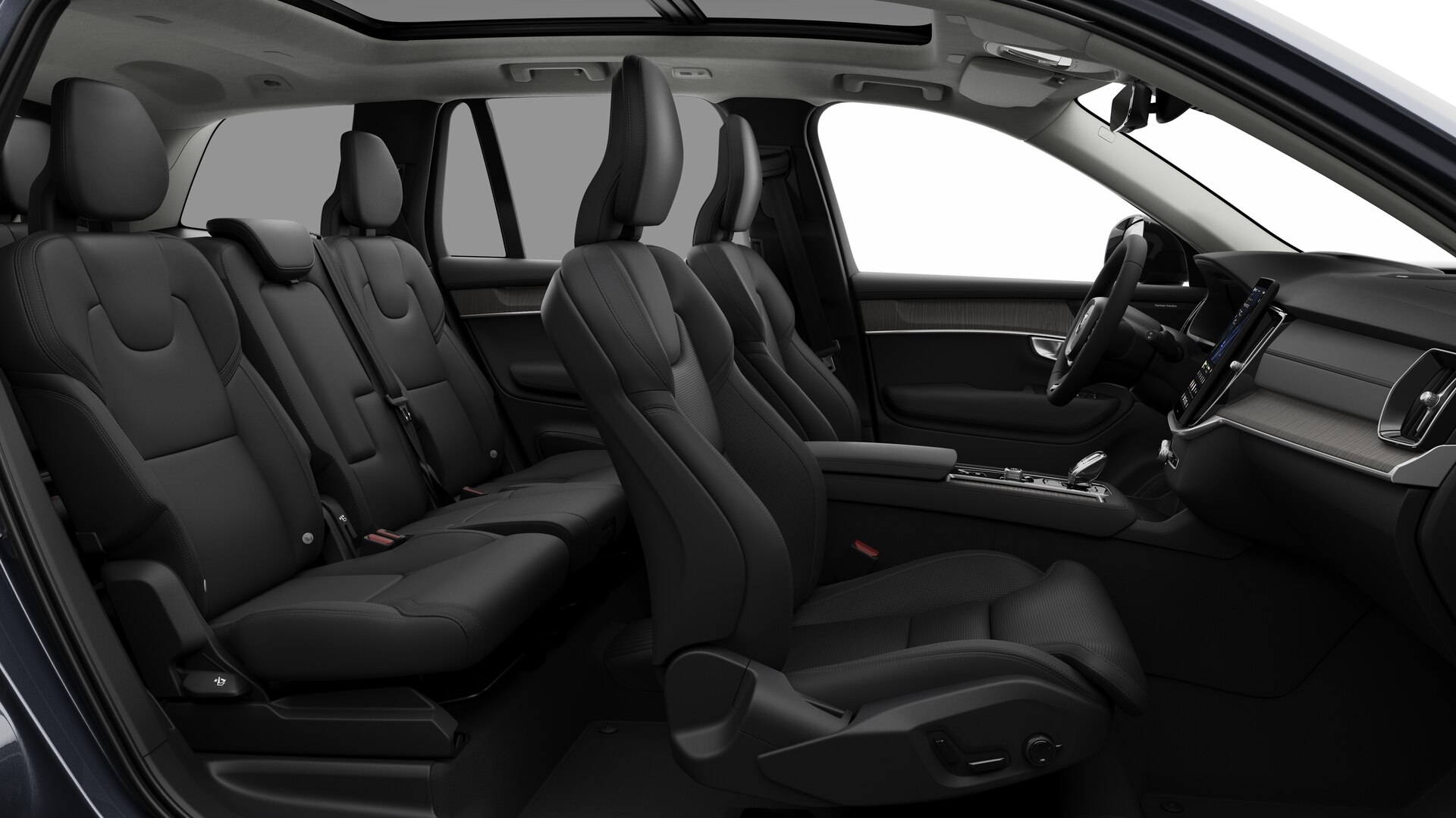 Vue latérale de l’intérieur d’une Volvo montrant les sièges avant, les sièges passager arrière, le volant, le tableau de bord et la console centrale, sur fond de studio.