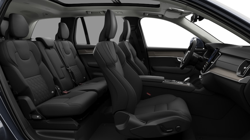 Volvo car interior side view showcasing front seats, rear passenger seats, steering wheel, dashboard, and center console, set against plain studio background.