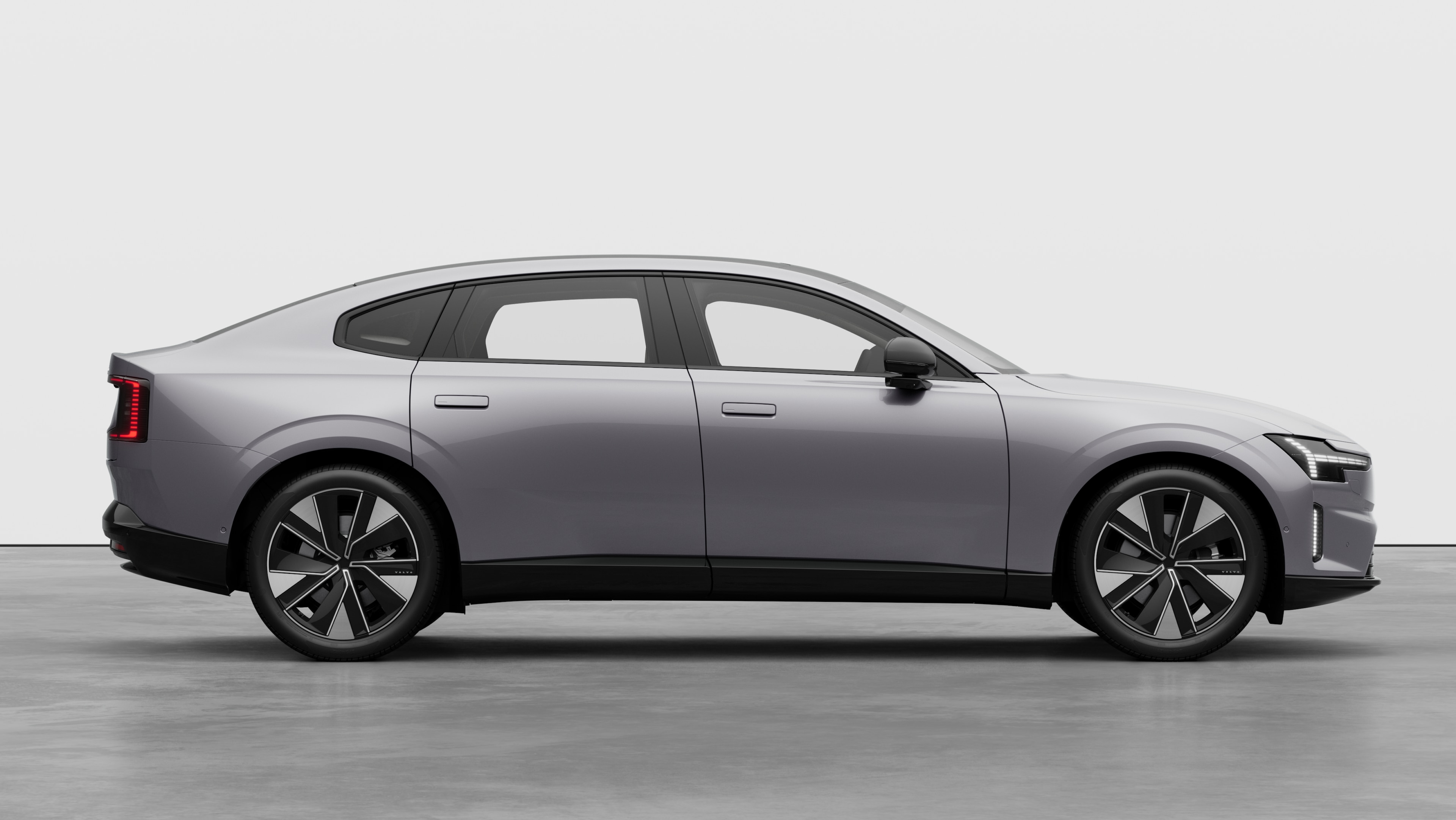 Volvo car side view on plain studio background displaying closed doors and visible wheel design.