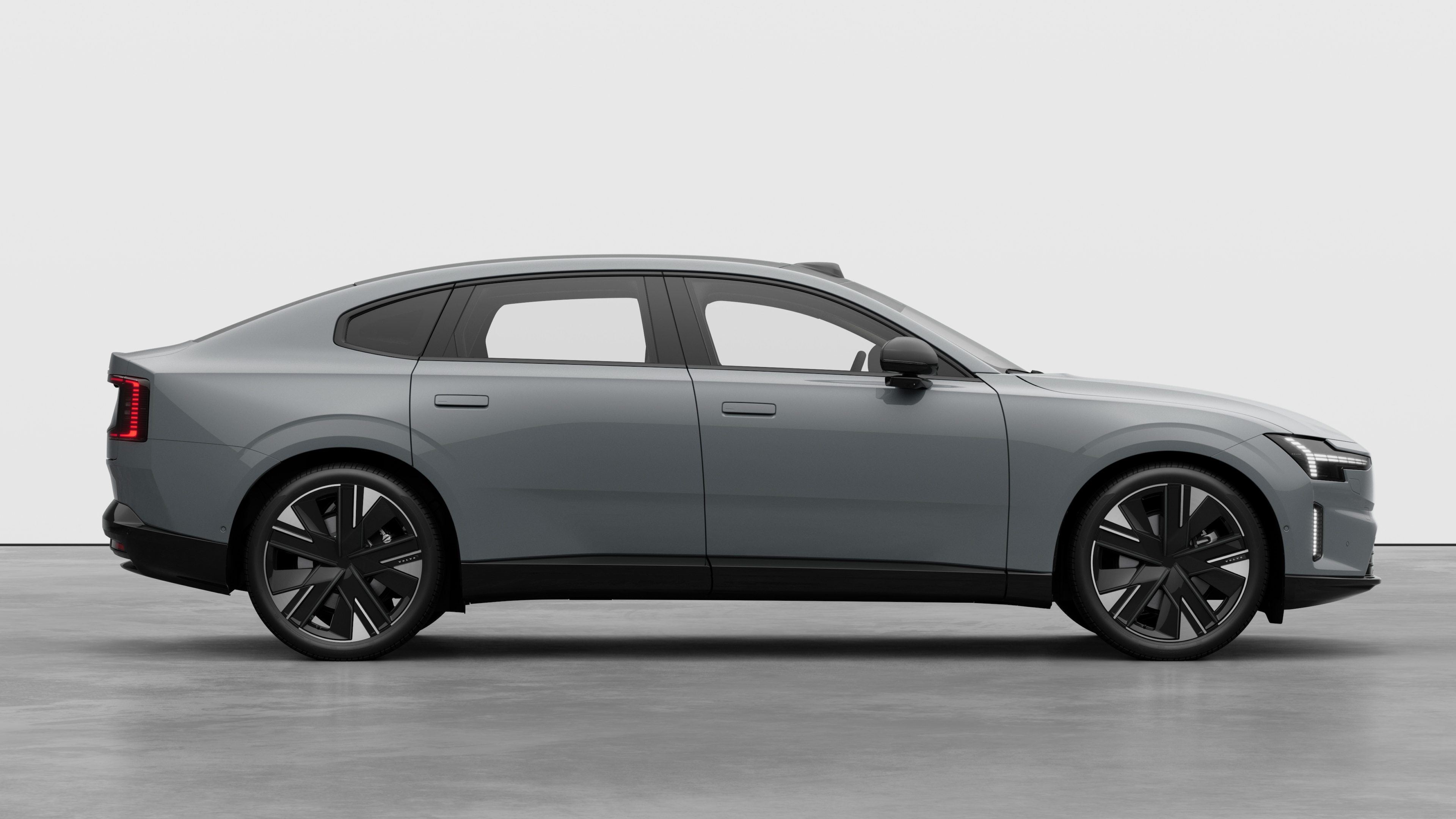 Sidovy från Volvo-bilen på en vanlig studiobakgrund som visar stängda dörrar och synlig fälgdesign.