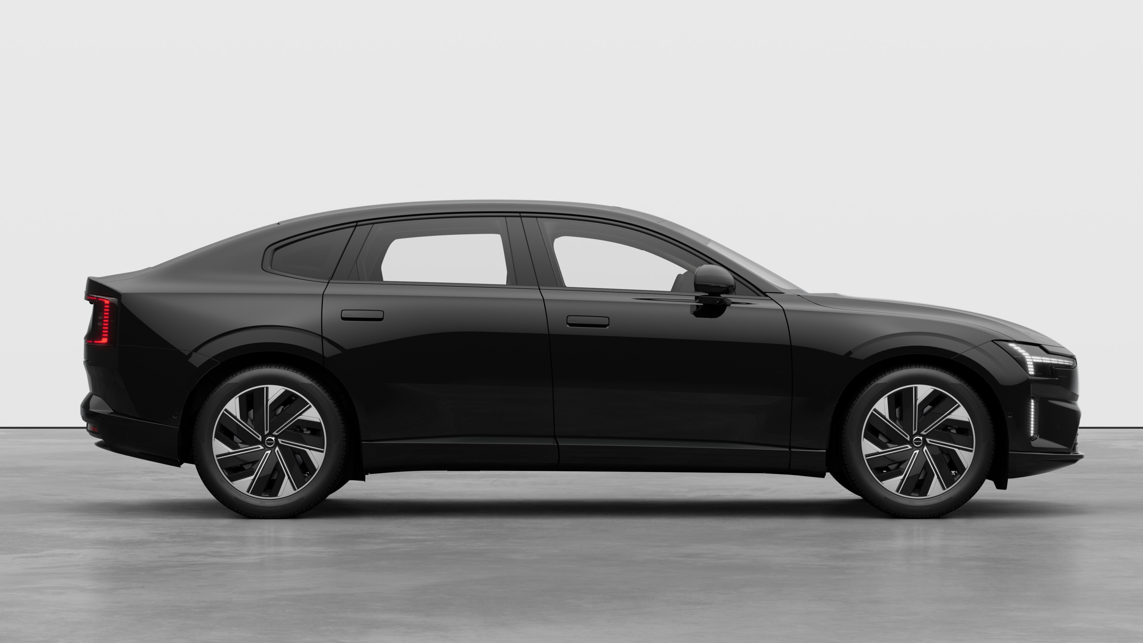 Volvo car side view on plain studio background displaying closed doors and visible wheel design.