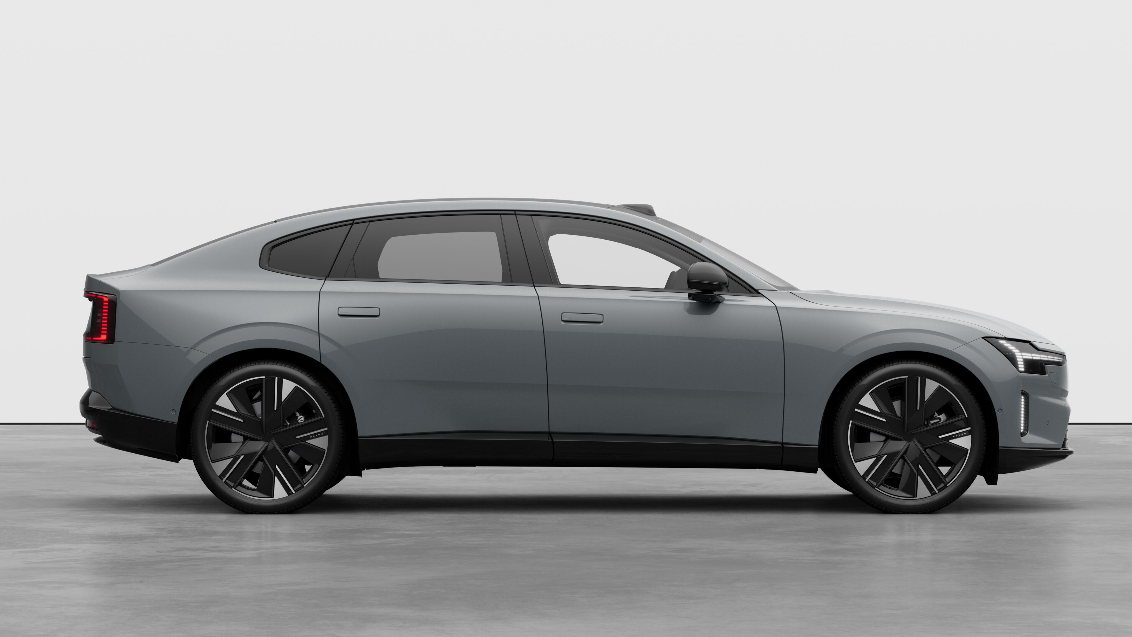 Volvo car side view on plain studio background displaying closed doors and visible wheel design.