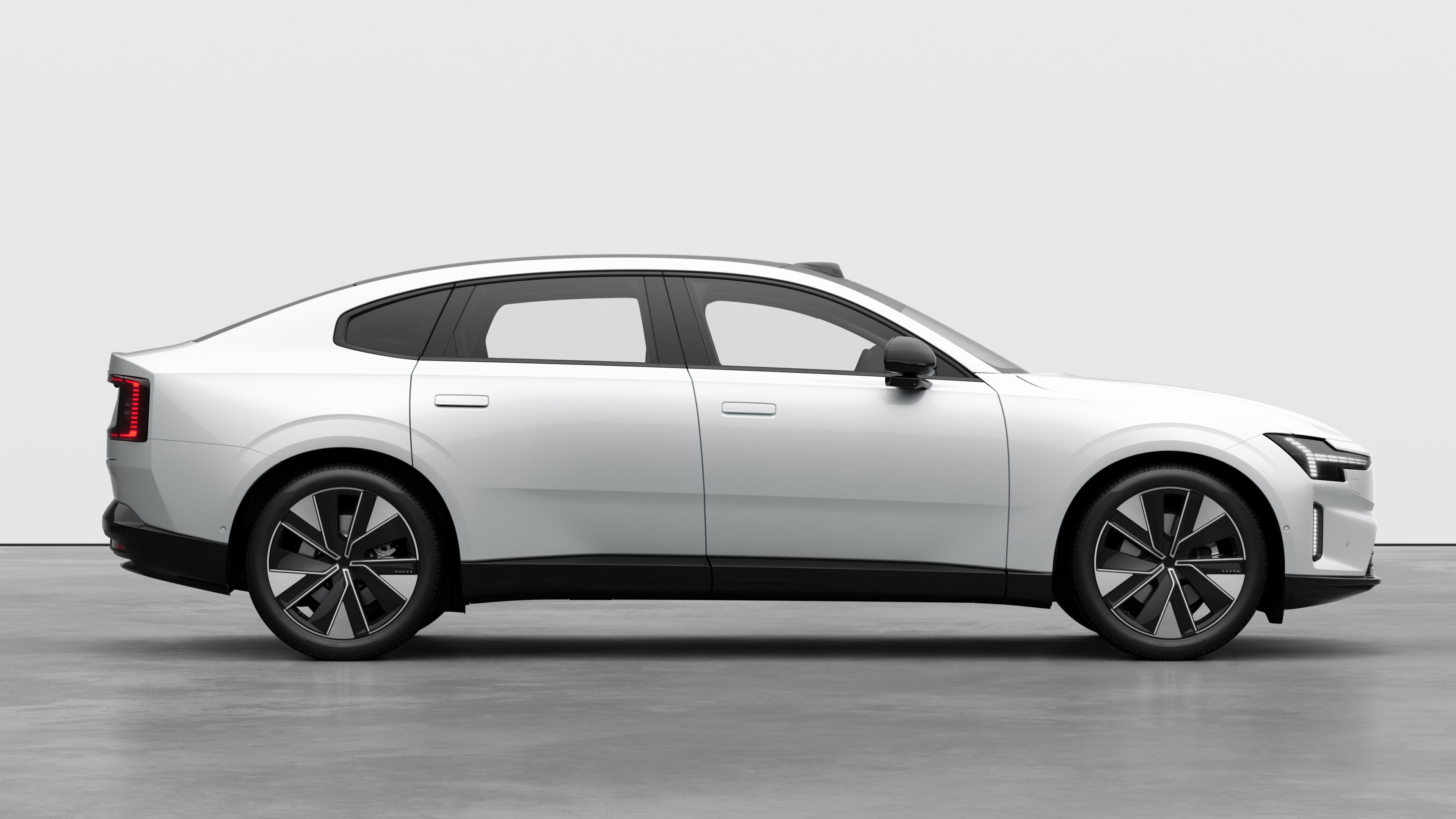 Volvo car side view on plain studio background displaying closed doors and visible wheel design.