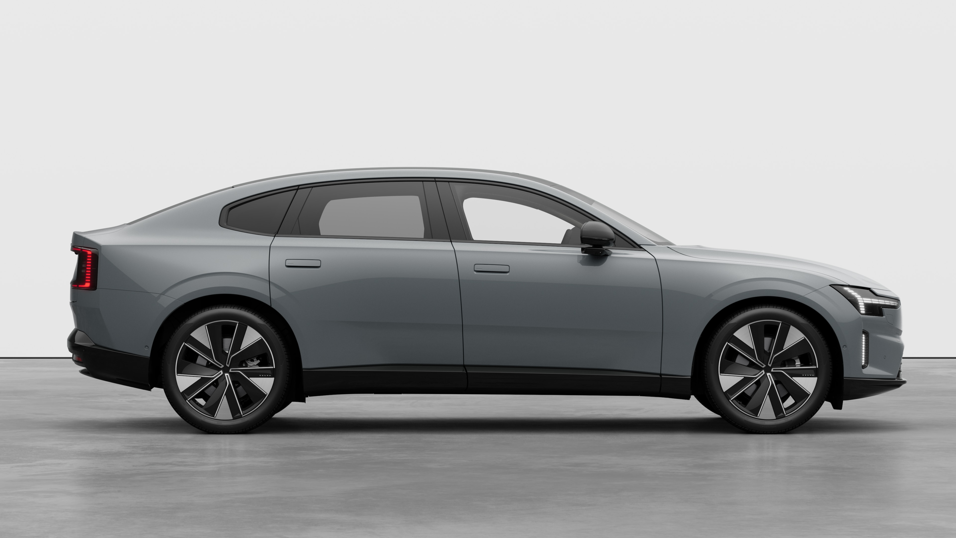 Volvo car side view on plain studio background displaying closed doors and visible wheel design.