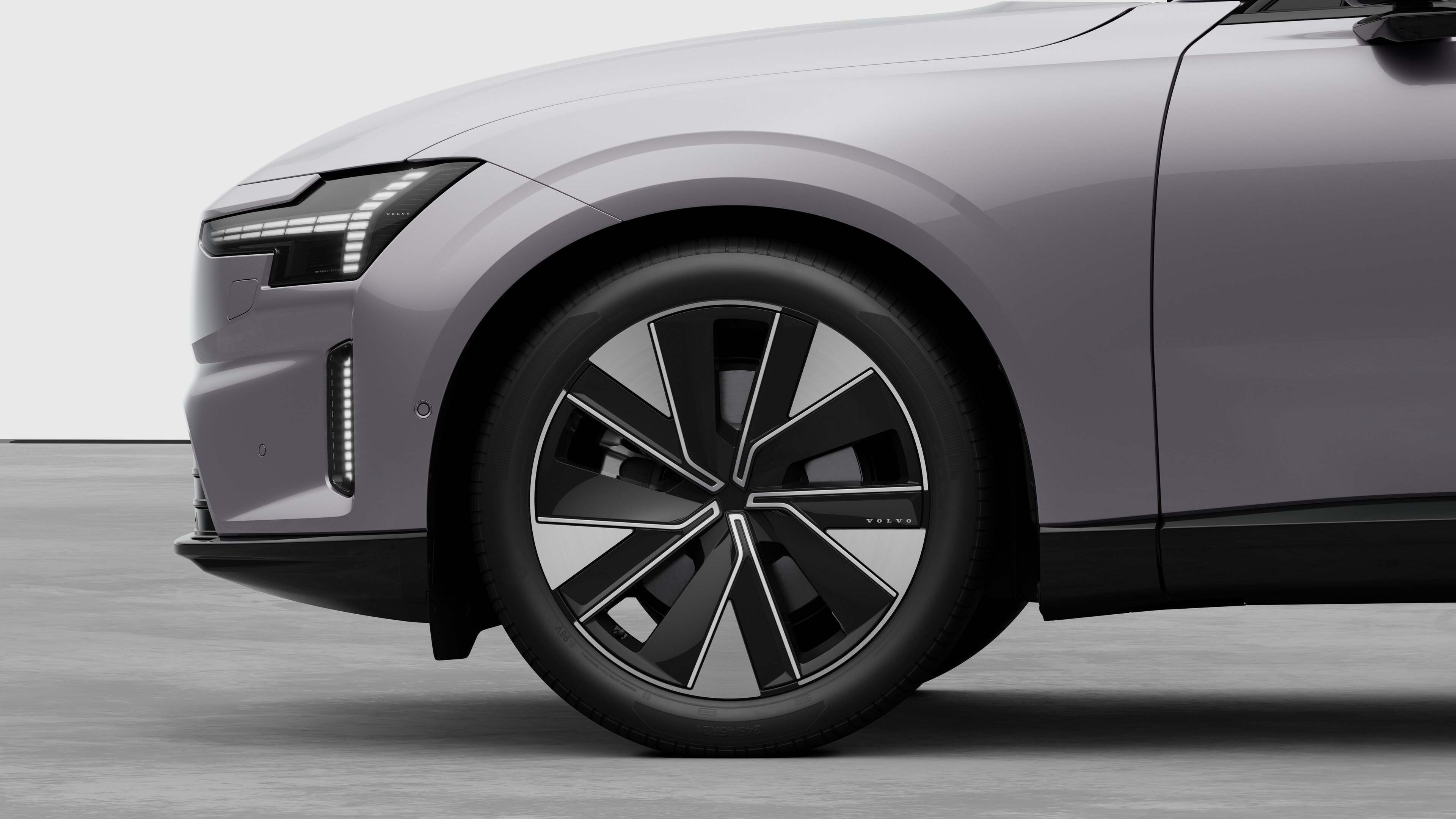 Volvo car exterior side view focusing on the front wheel and fender, set against a plain studio background.