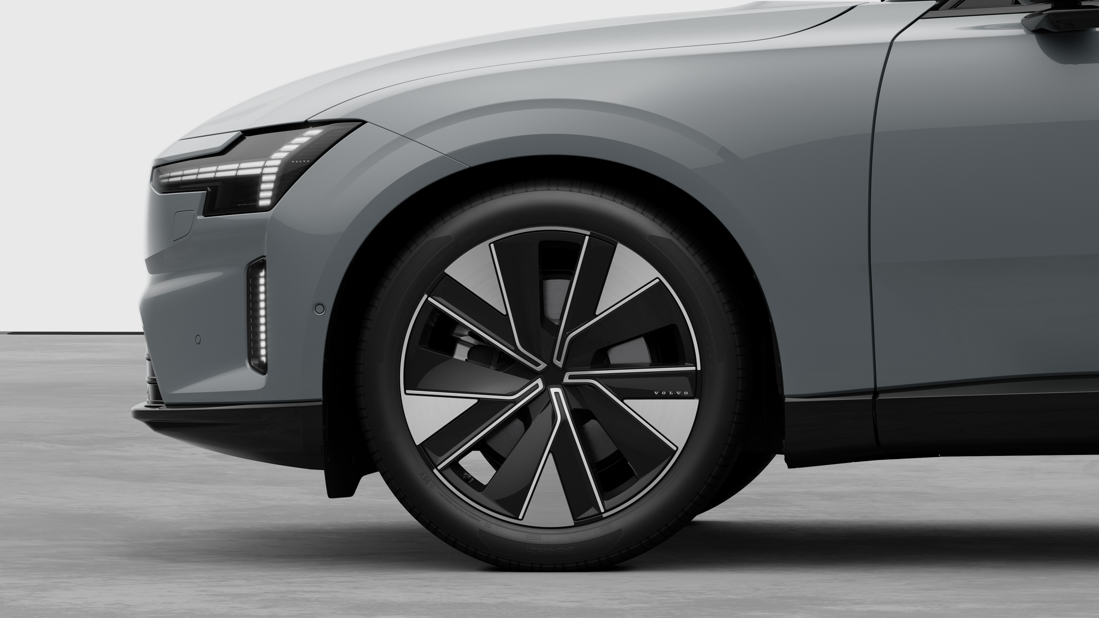 Volvo-bilens udvendige sidebillede med fokus på forhjulet og skærmen, sat op mod en almindelig studiebaggrund.